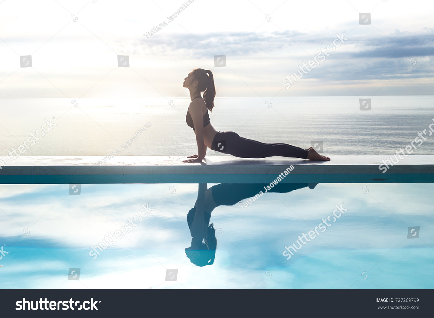 Vacation of Calm Attractive Asian woman practice yoga Cobra Pose on the pool above beach in the morning with beautiful sea in Tropical island,comfortable and relax in holiday.Yoga Vacations Concept #727269799
