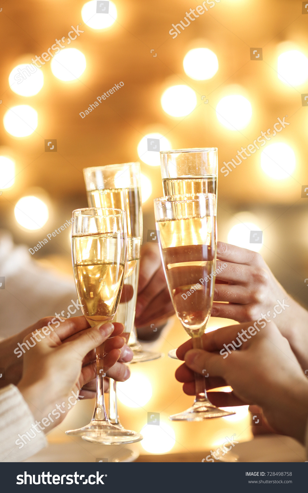 Champagne glasses in hands on golden background. Party and celebration concept #728498758