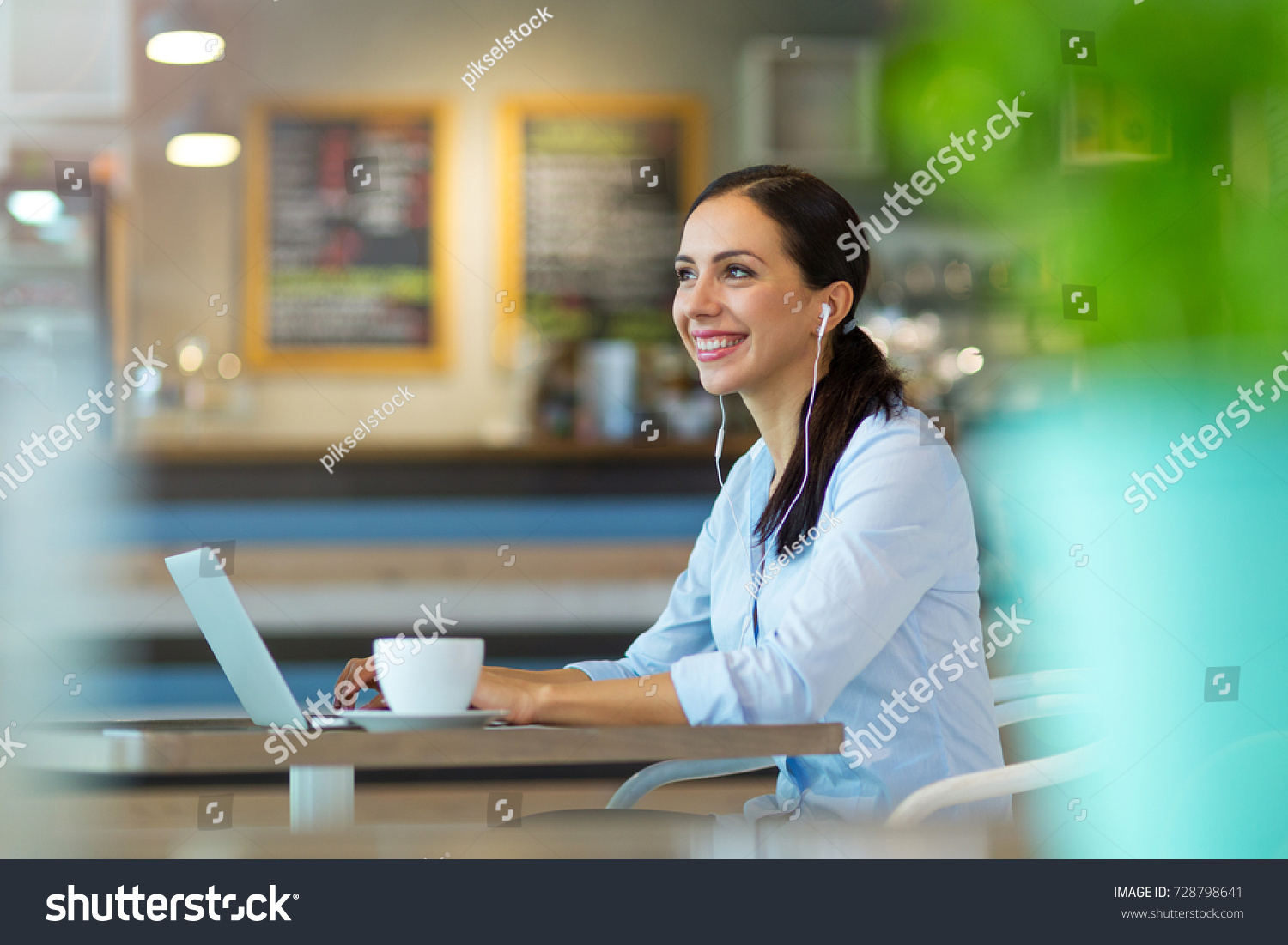 Woman using laptop in cafe
 #728798641