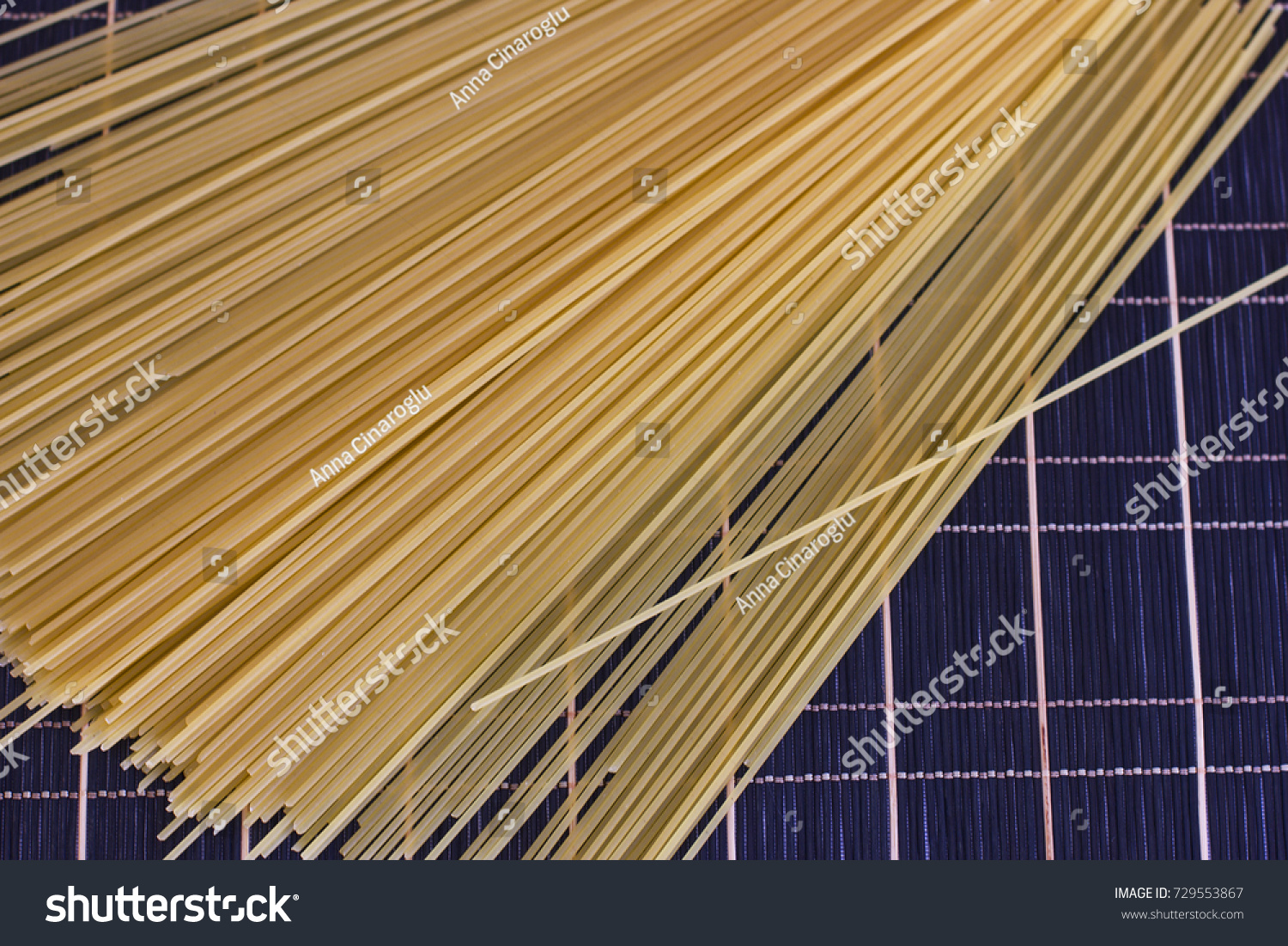 Raw spaghetti on a checkered dark table #729553867
