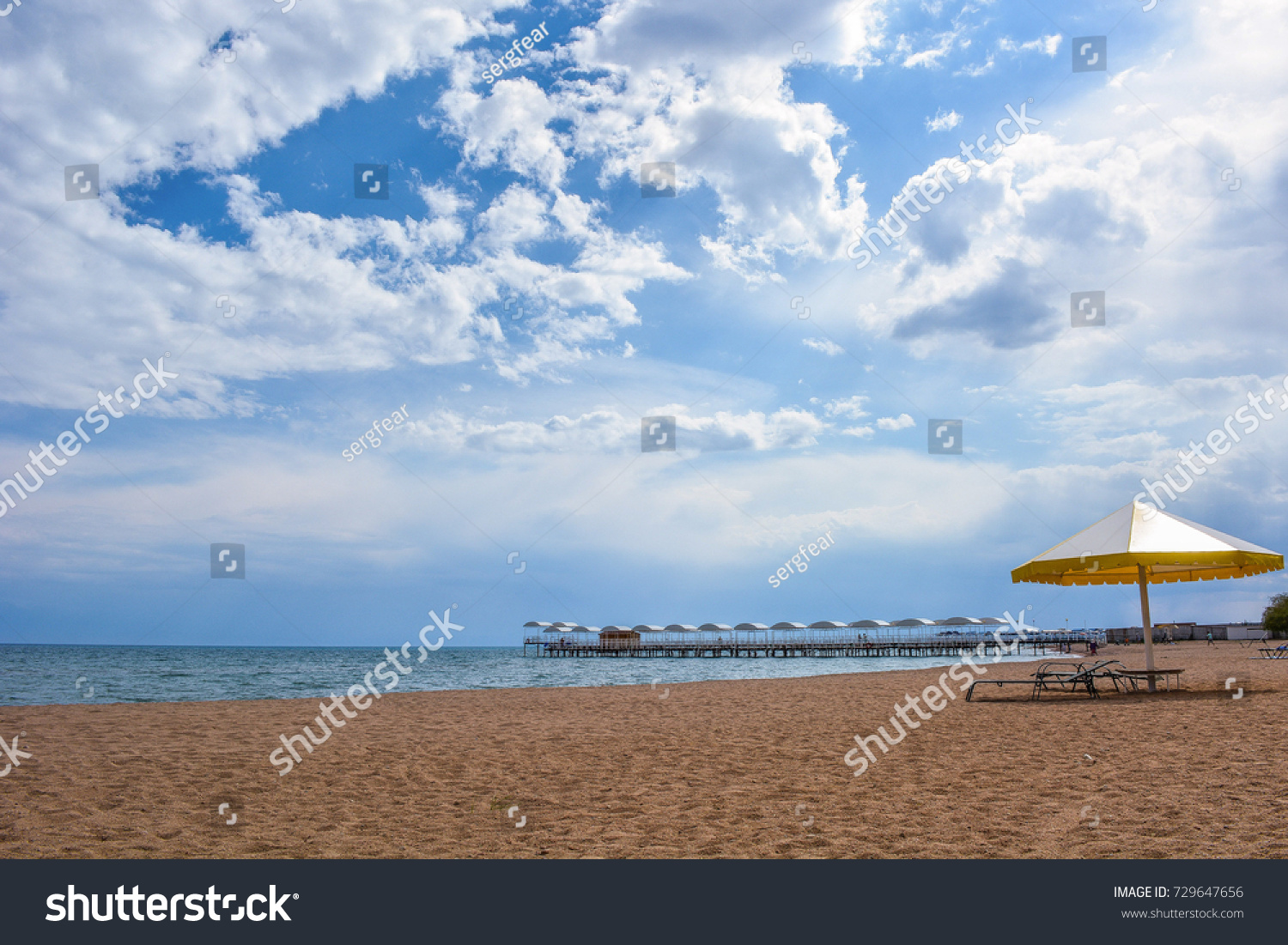 Beautiful scenic view - distant open wood amid the calm water of Issyk-Kul Lake against the background of Tien Shan mountain range and cloudy blue sky, Kyrgyzstan, Central Asia #729647656