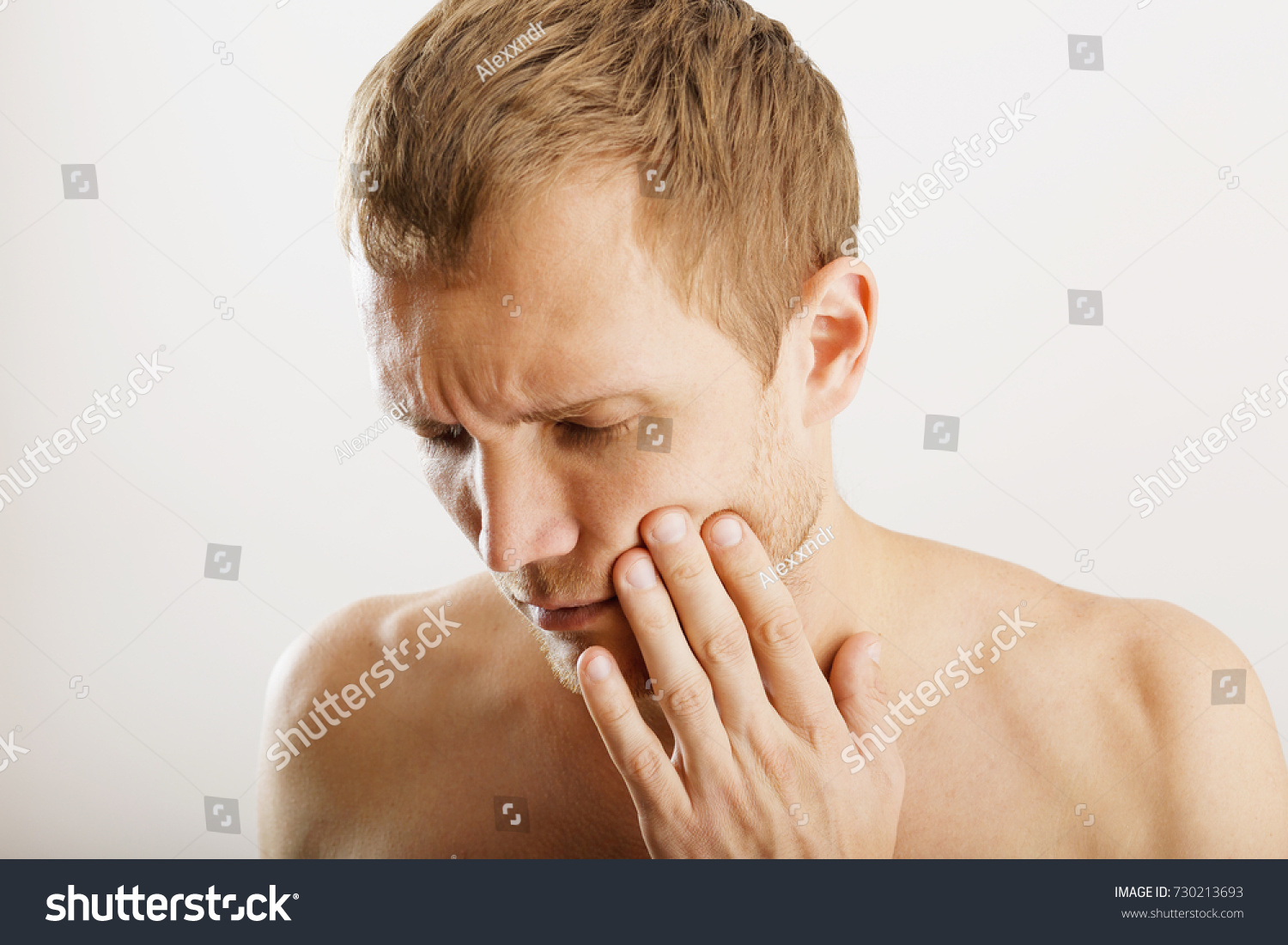 man holds his hand near the cheek, toothache, white background in the studio #730213693