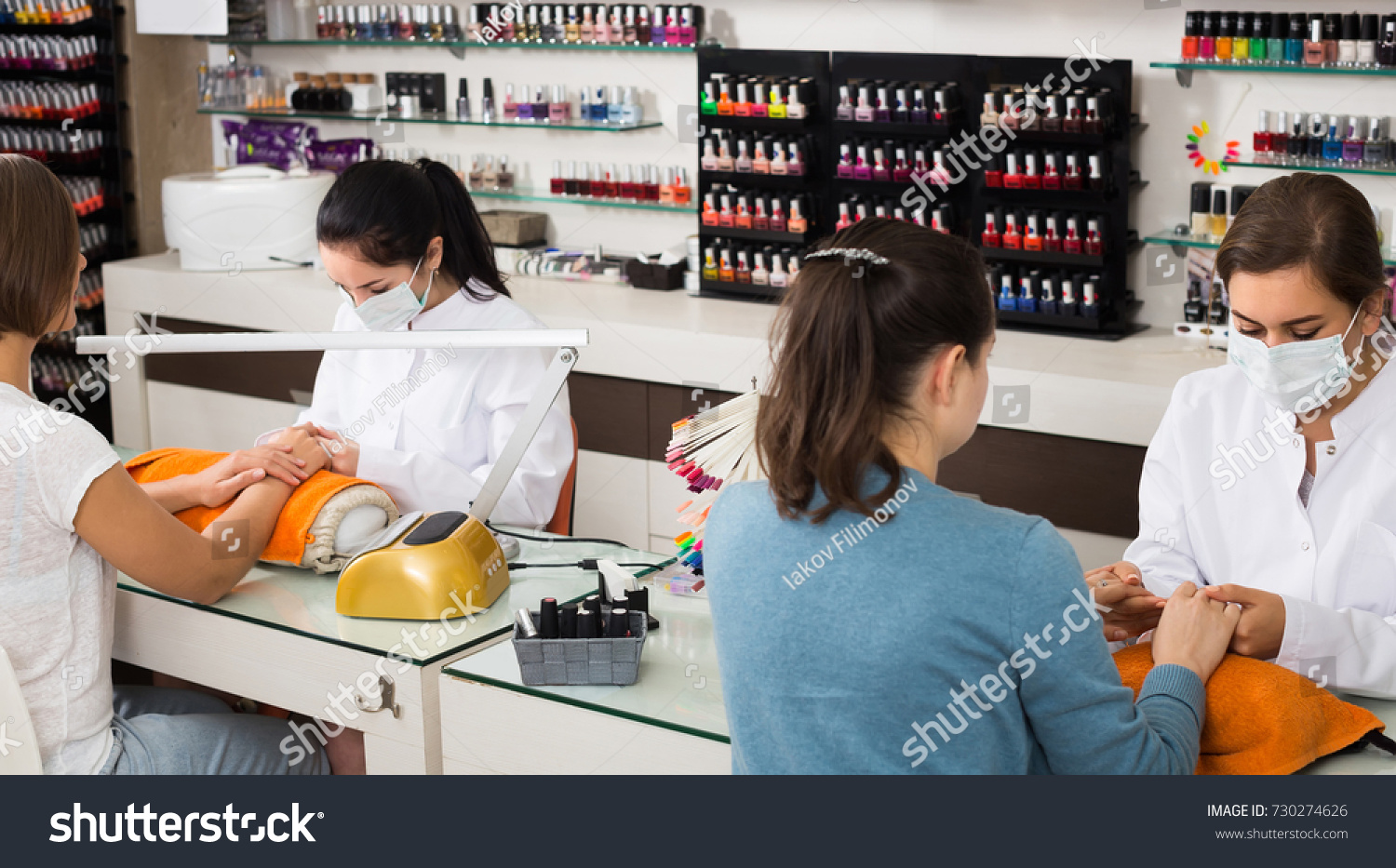 Happy american women getting their nails done at beauty salon #730274626