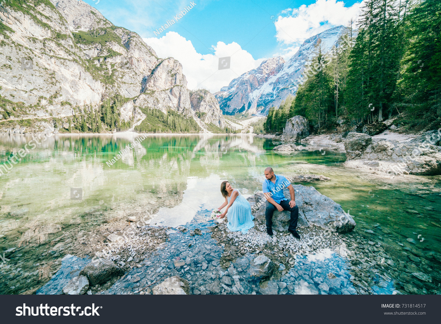 Young couple near lake lago di braies,Dolomite,Italy hold the hand stand at the stone at lake. #731814517