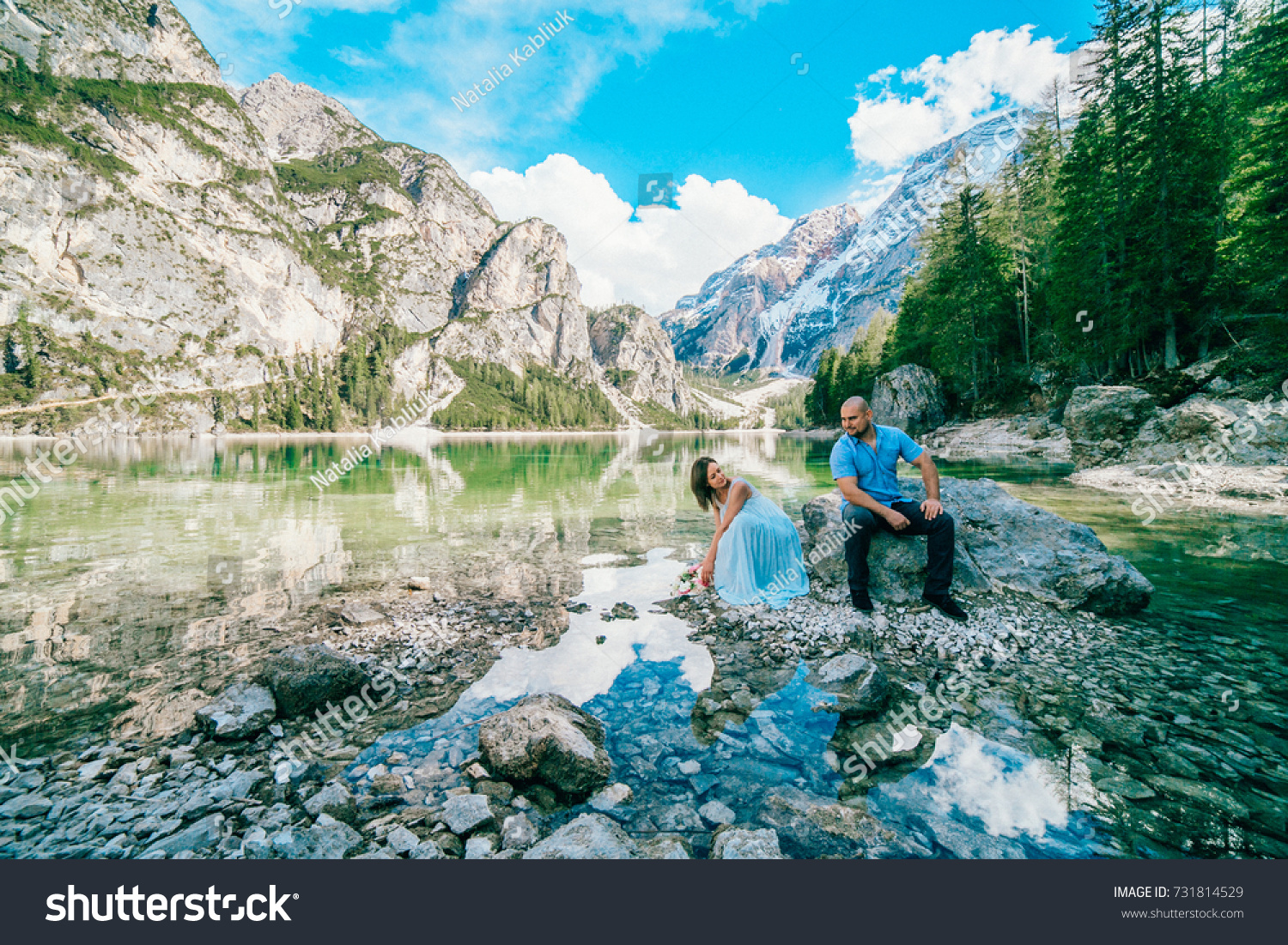 Young couple near lake lago di braies,Dolomite,Italy hold the hand stand at the stone at lake. #731814529