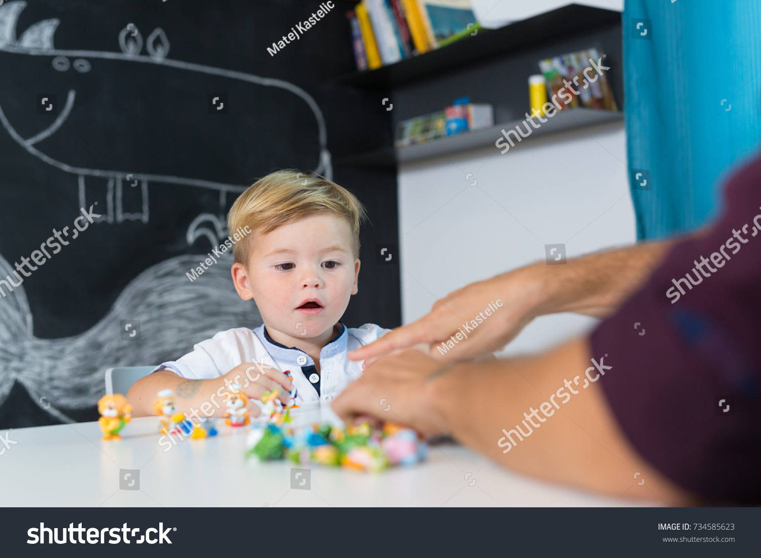 Cute little playfull toddler boy at child therapy session. Private one on one homeschooling with didactic aids. #734585623