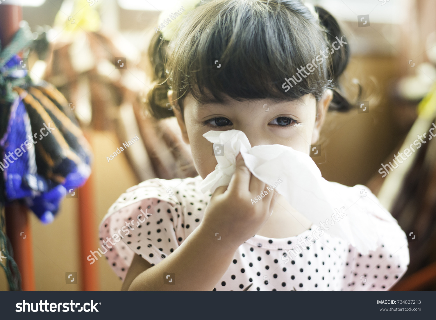Asian little girl with handkerchief. Sick child  has runny nose. #734827213