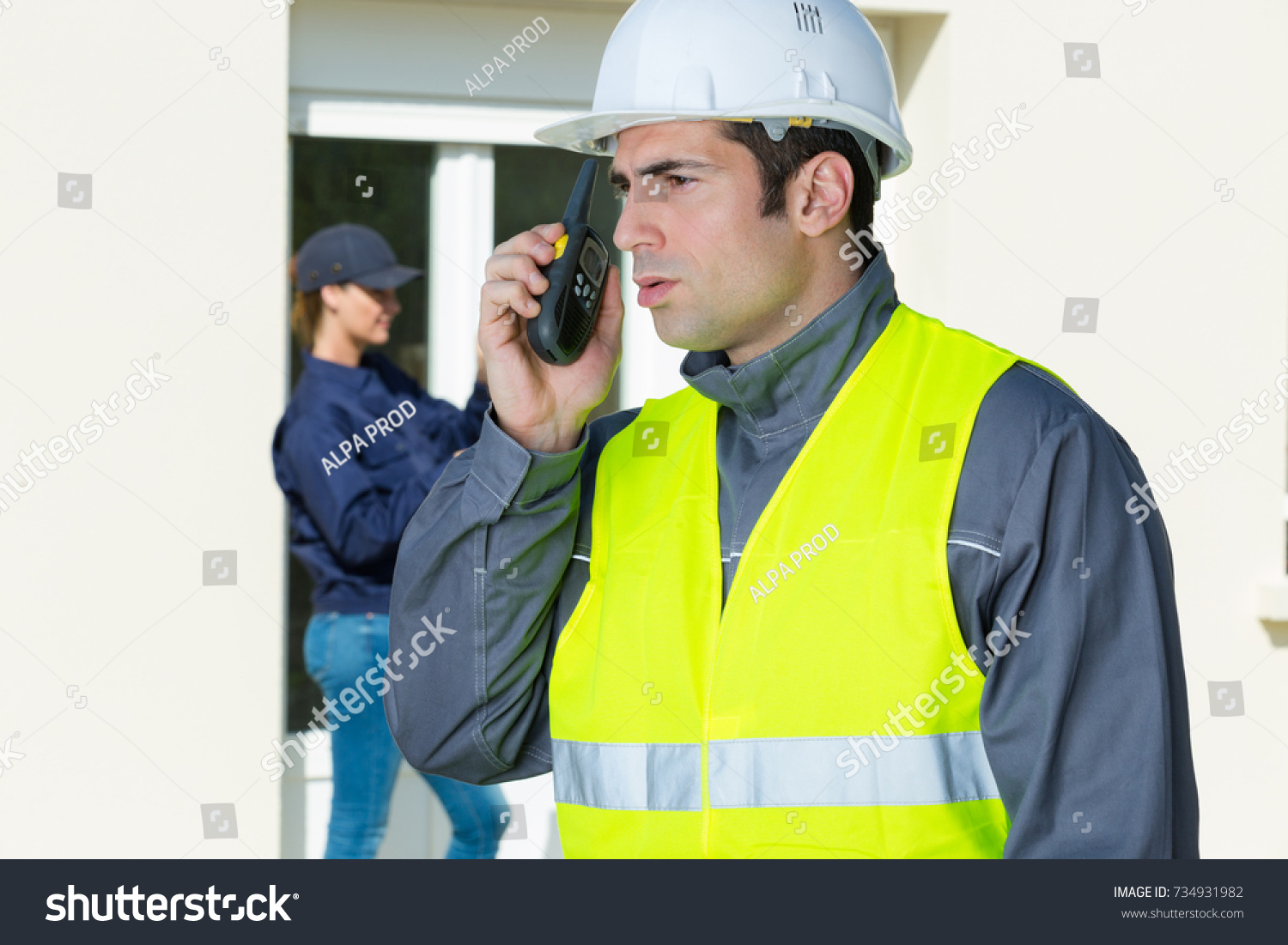 male builder in hardhat with walkie talkie #734931982