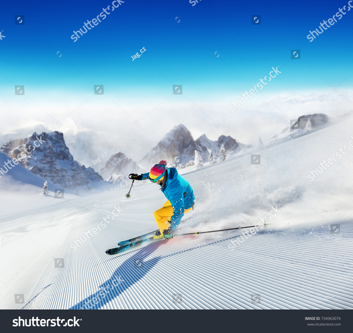 Young man skier running down the slope in Alpine mountains. Winter sport and recreation, leisure outdoor activities. #734963074