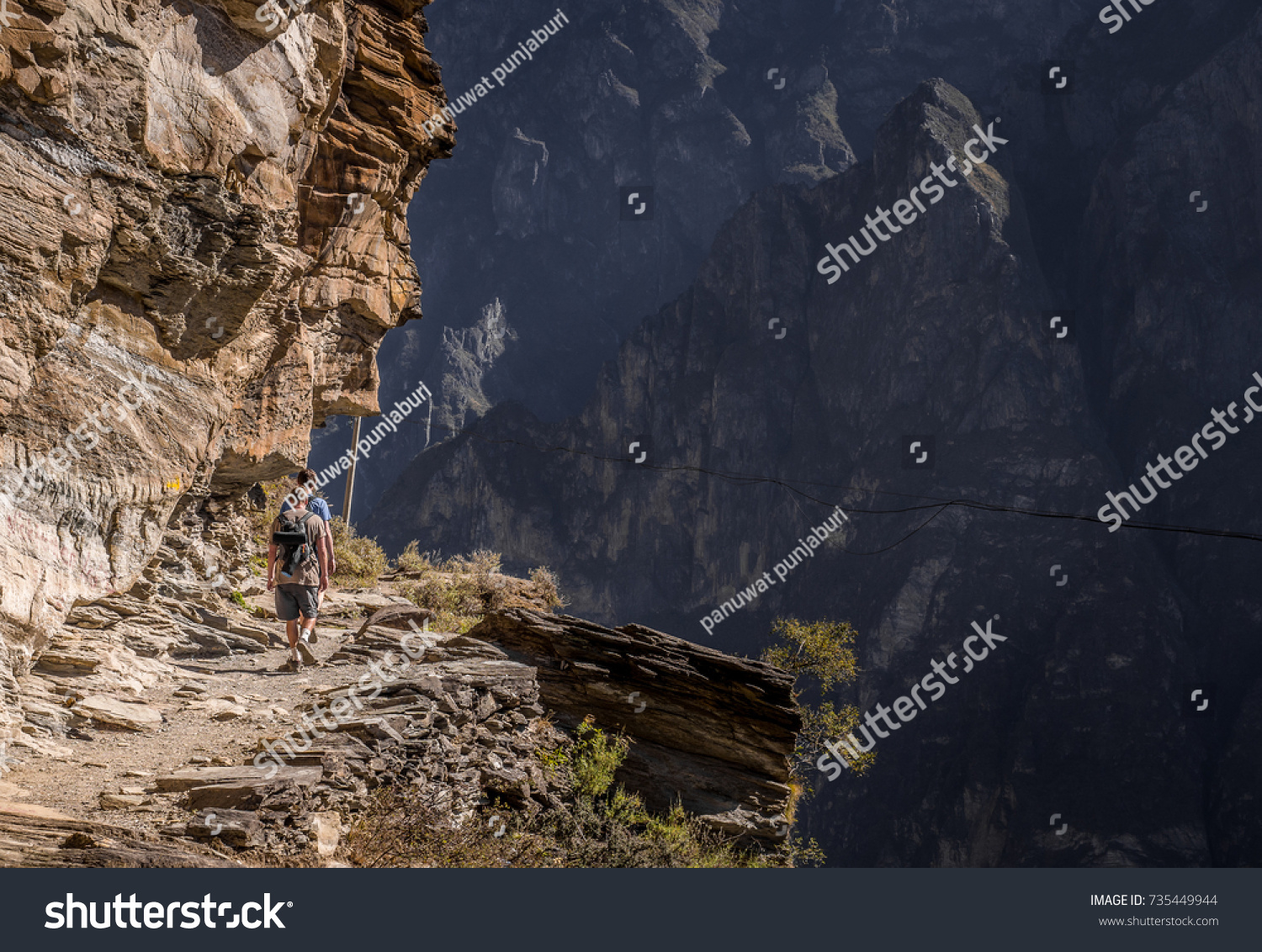 men hiking on the rocky mountain and the beautiful landscape of tiger leaping gorge,China #735449944