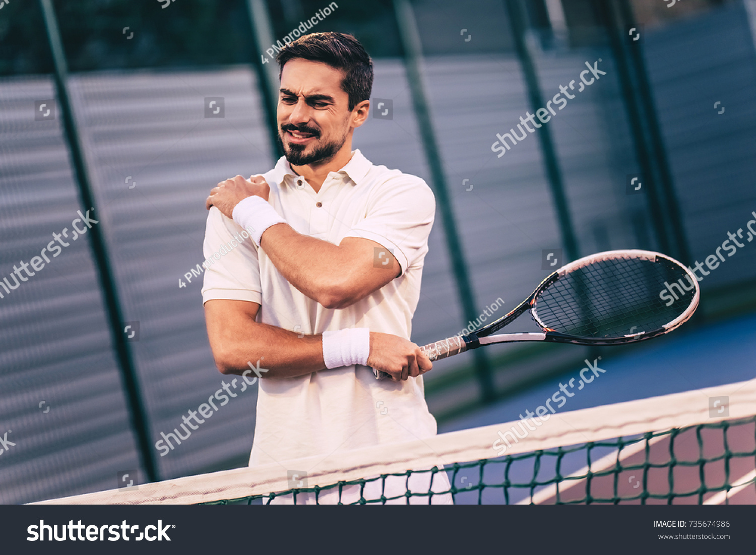 Handsome man on tennis court. Young tennis player. Shoulder pain #735674986