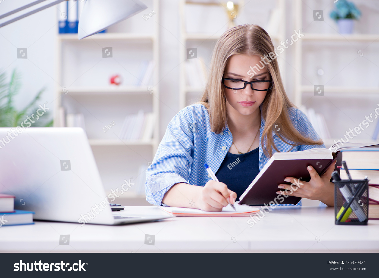 Young teenage female student preparing for exams at home #736330324