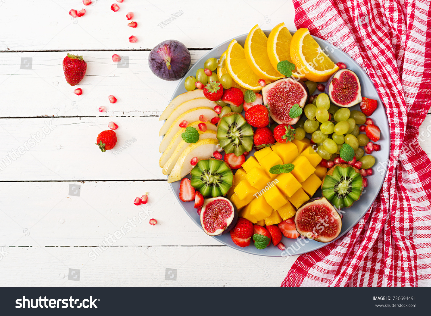 Platter fruits and berries. Mango, kiwi, fig, strawberry, grapes, pear and orange. Vegan cuisine. Dietary menu. Flat lay. Top view #736694491
