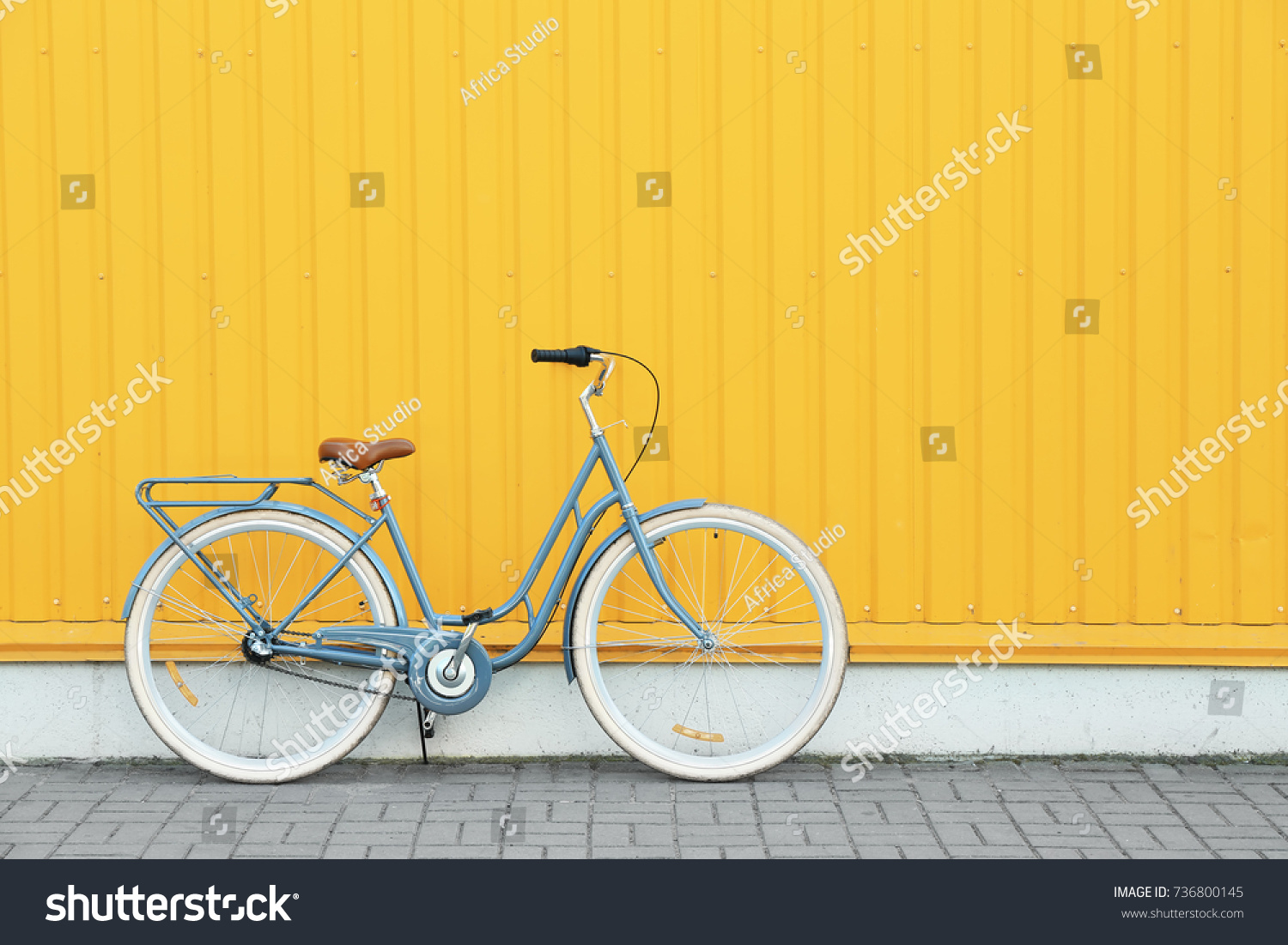 Retro bicycle near yellow wall outdoors #736800145