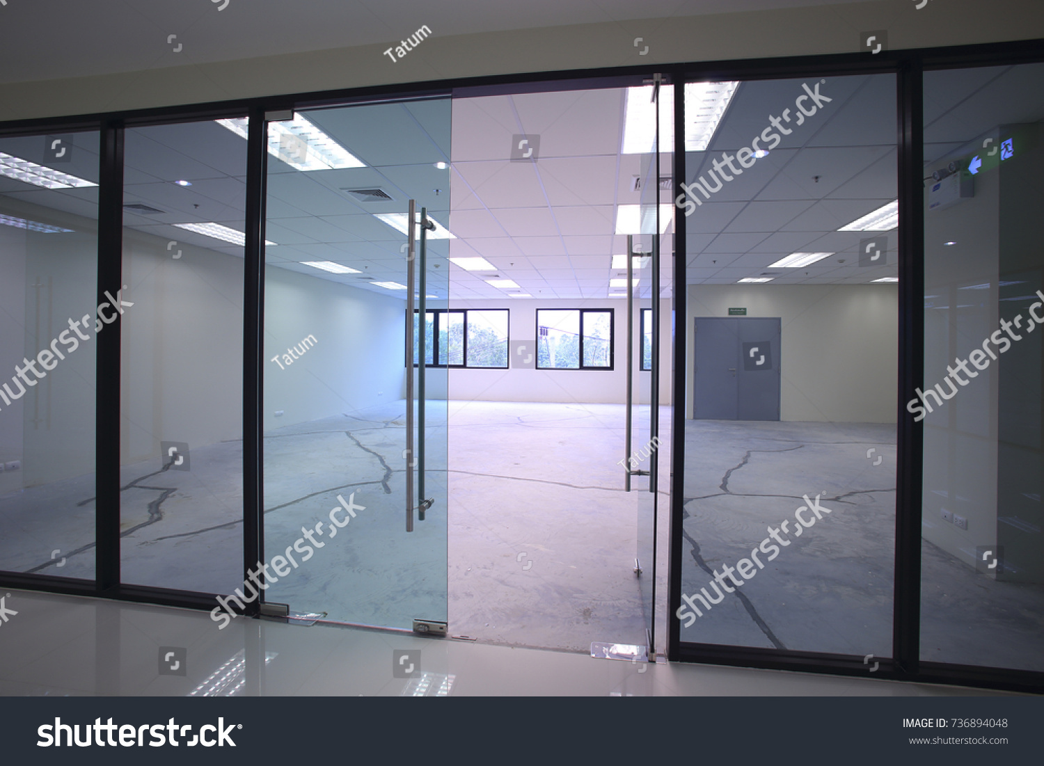 Interior empty office light room with white wallpaper without furniture in a new building renovation or under construction.Glass doors and Windows. #736894048