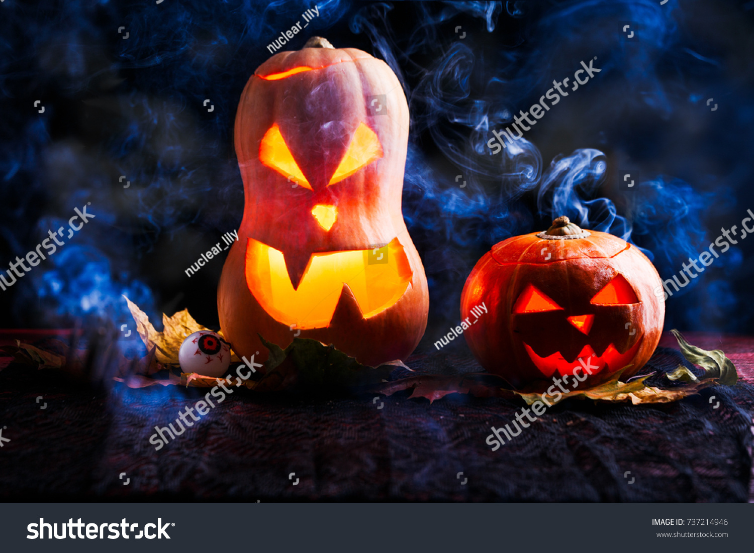 Image of two halloween pumpkins with eyeballs on black background with smoke #737214946
