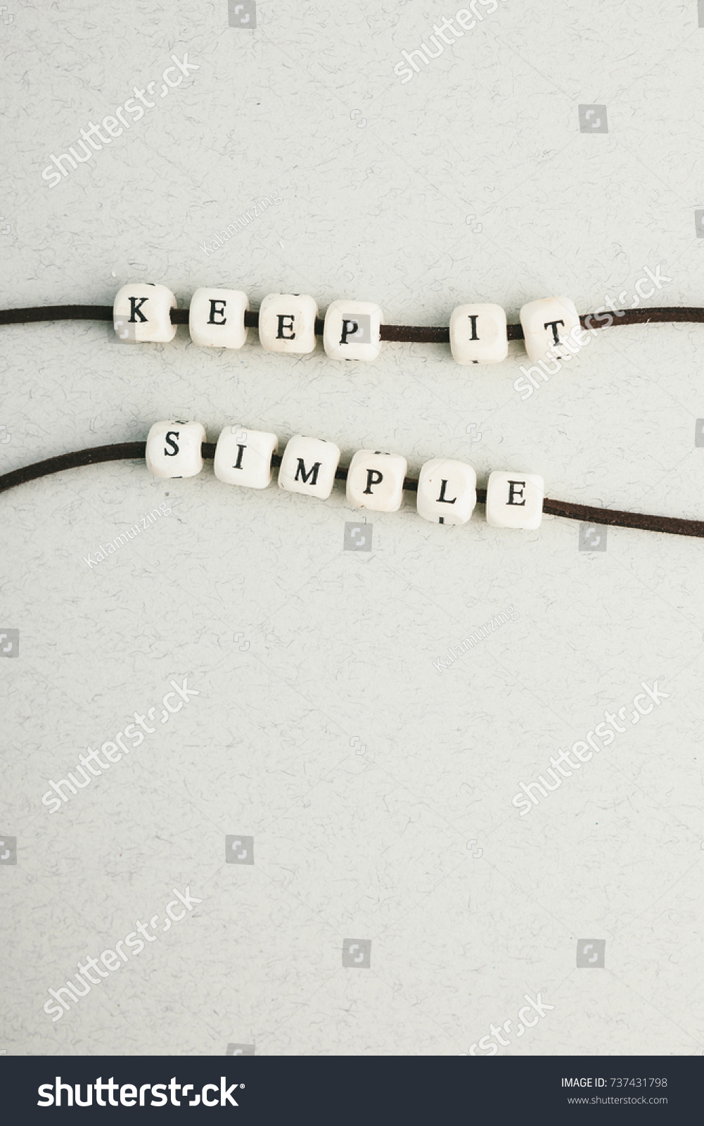 Motivation phrase Time is now from wooden beads strung on leather cord. Vertical composition. a series of photos with words and phrases #737431798