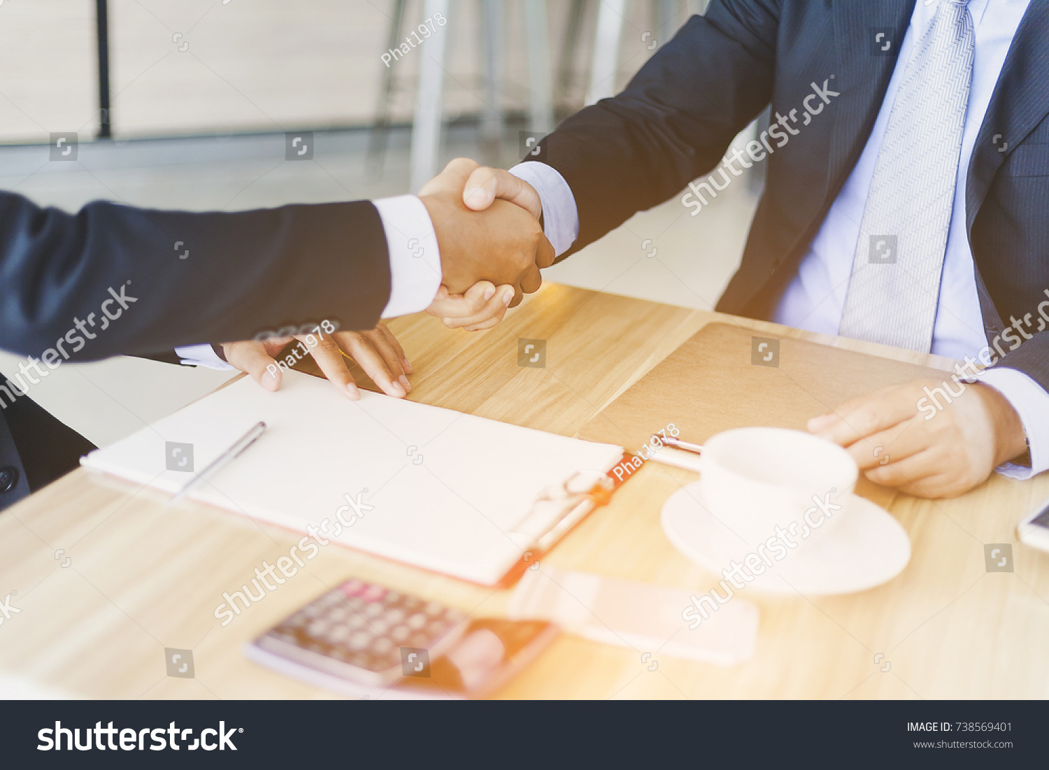 Investors reassure businessman or foreign partners in real estate investment new project. Lawyers join hands with clients to agree on the job with confidence while checking documents at coffee shop. #738569401