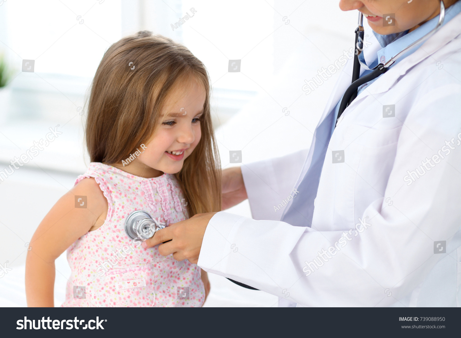 Doctor examining a little girl by stethoscope #739088950