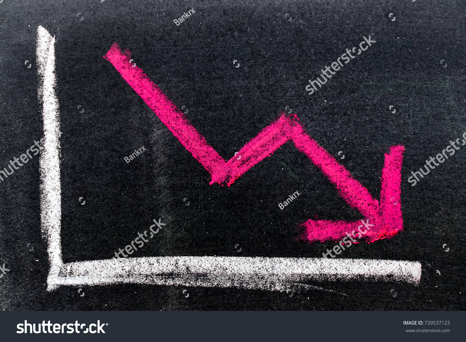 Red color hand drawing chalk in arrow down shape on black board background (Concept of stock decline, down trend of business, economy) #739537123
