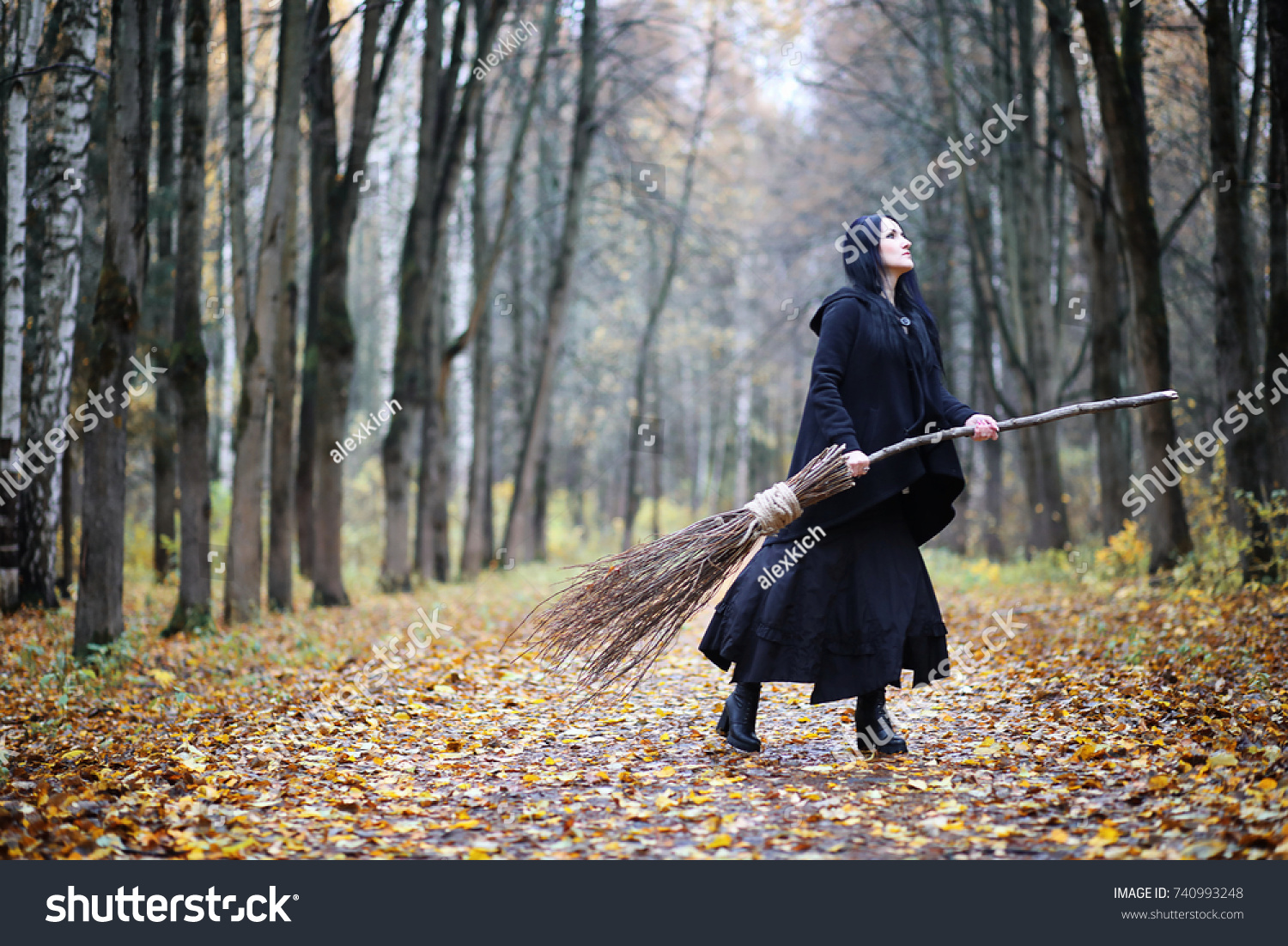 A woman in a witch suit in a dense forest on a ritual #740993248