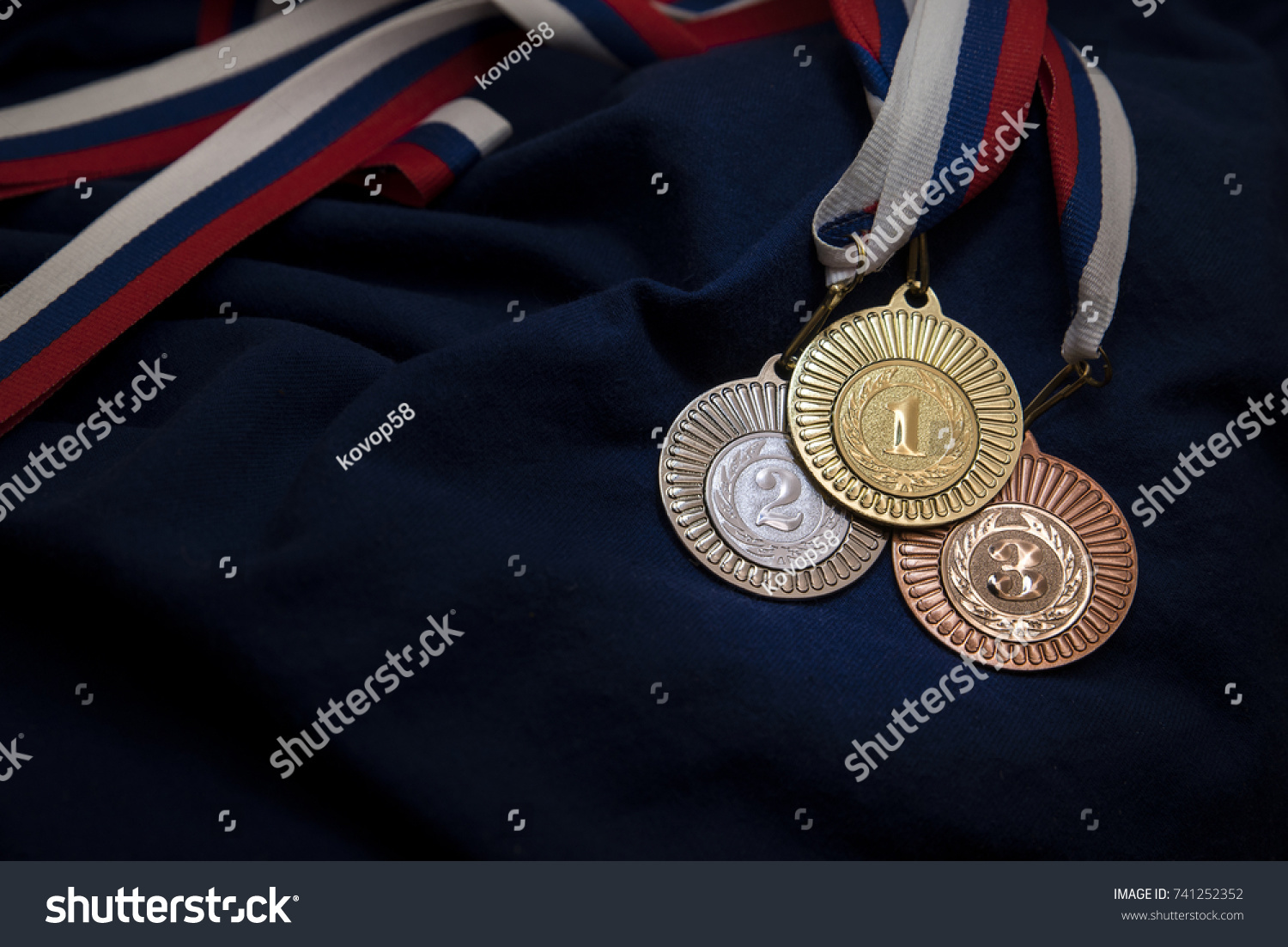 Gold, silver and bronze medal with numbers One, Two and Three. Sport trophy. Blue background. Original photo for winter olympic game in pyeongchang 2018. #741252352