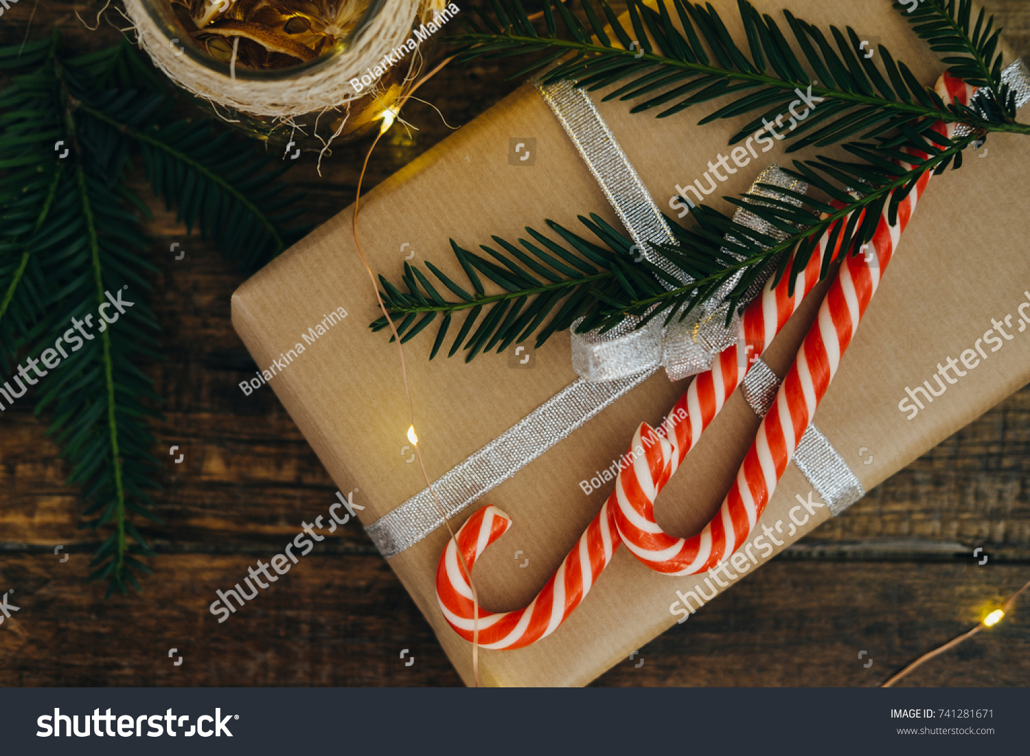 Top View Christmas present with candy canes and Fir tree branch on dark wooden background. Selective focus #741281671
