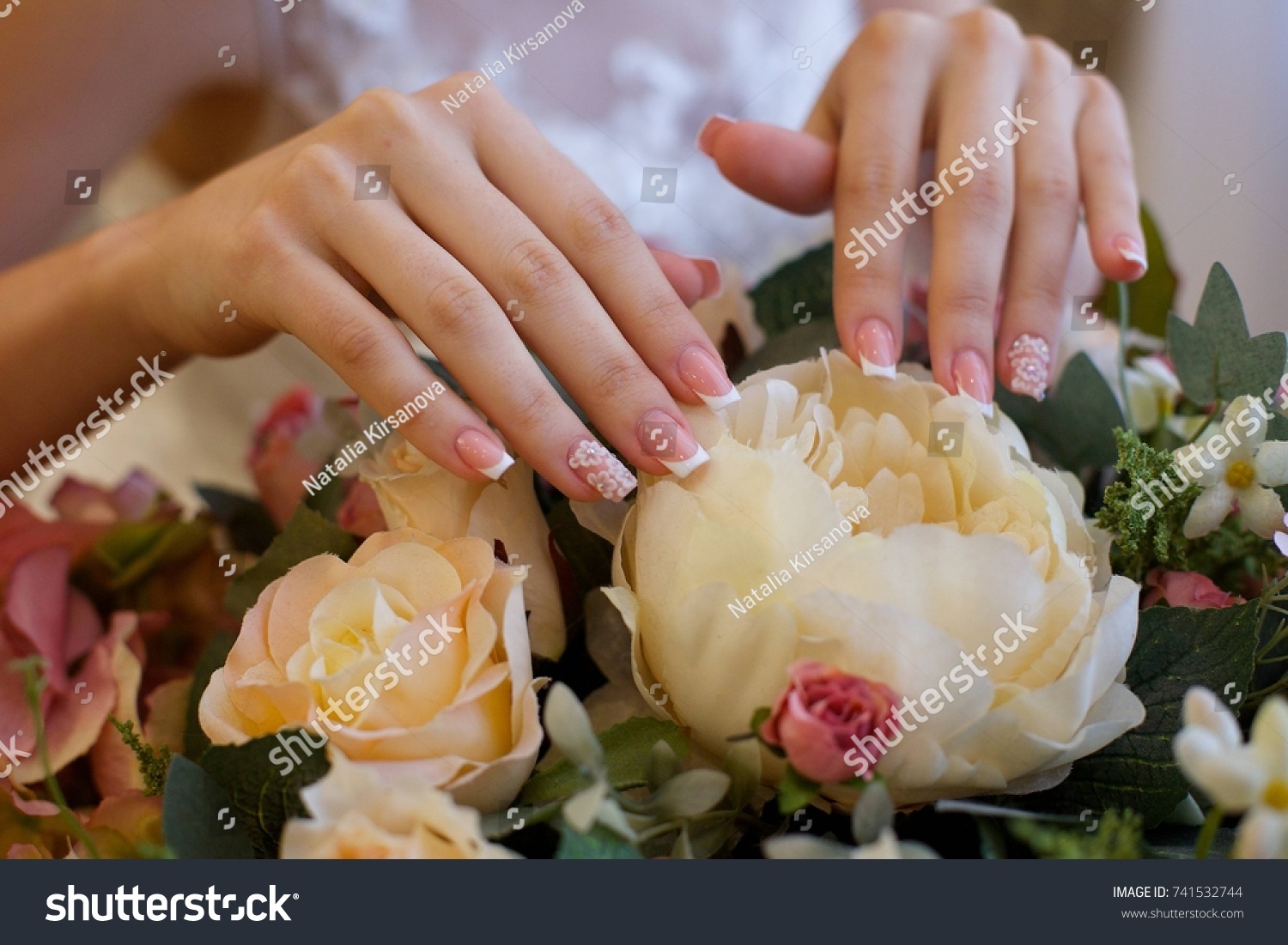 Elegant female hands of bride in white dress #741532744