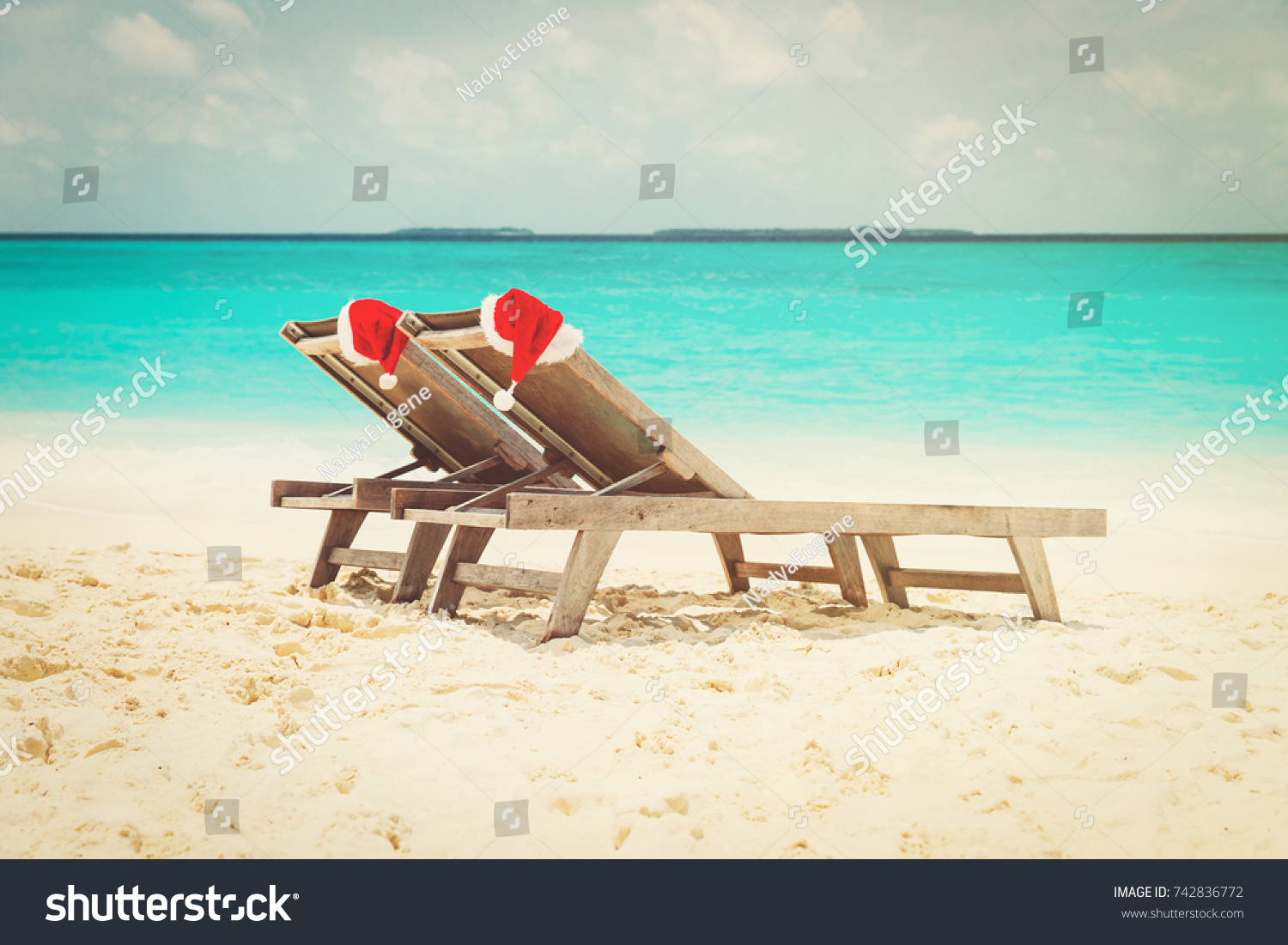 Christmas at the beach - chair lounges with Santa hats at sea #742836772