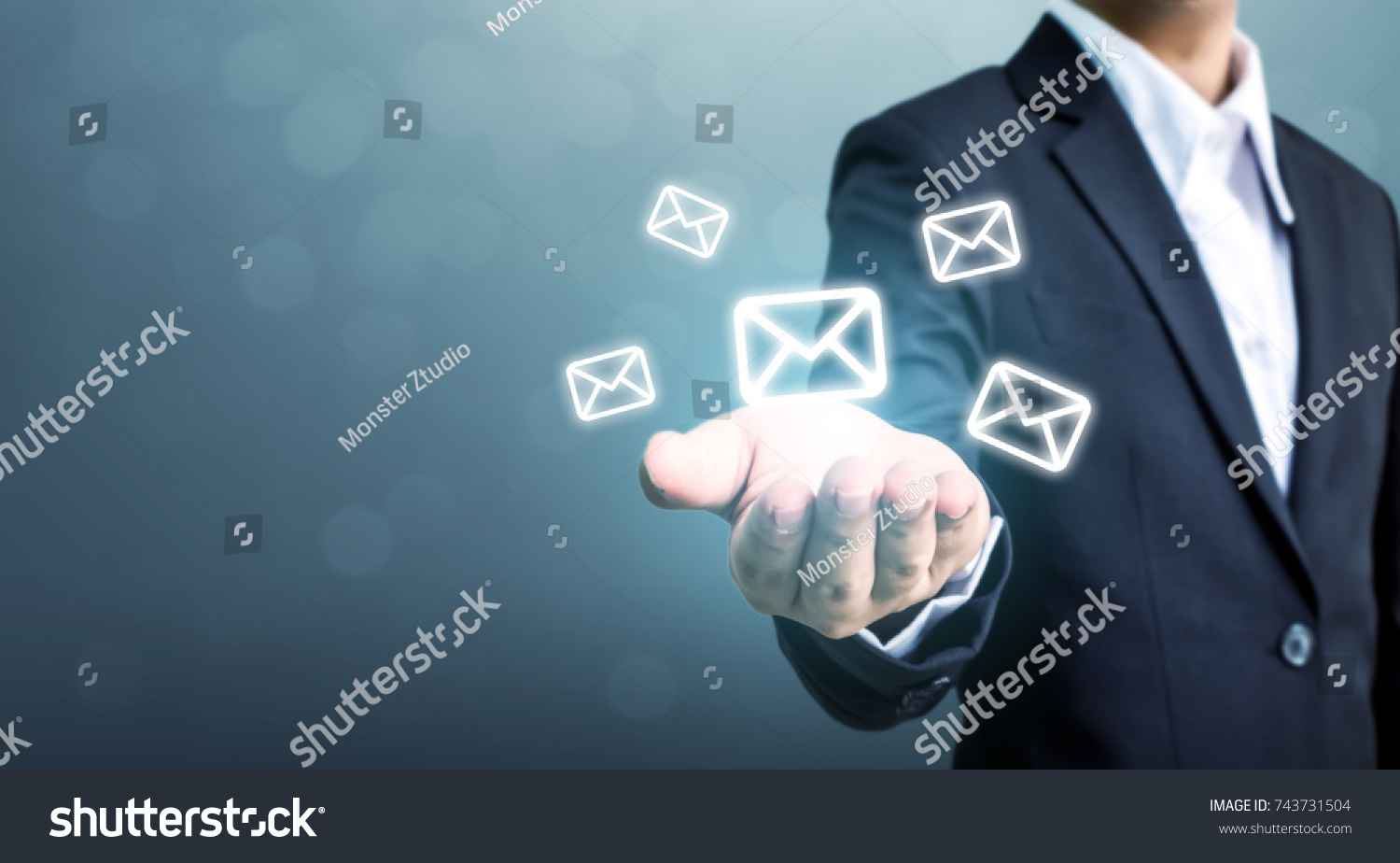 Businessman hand holding e-mail icon, Contact us by newsletter email and protect your personal information from spam mail concept #743731504