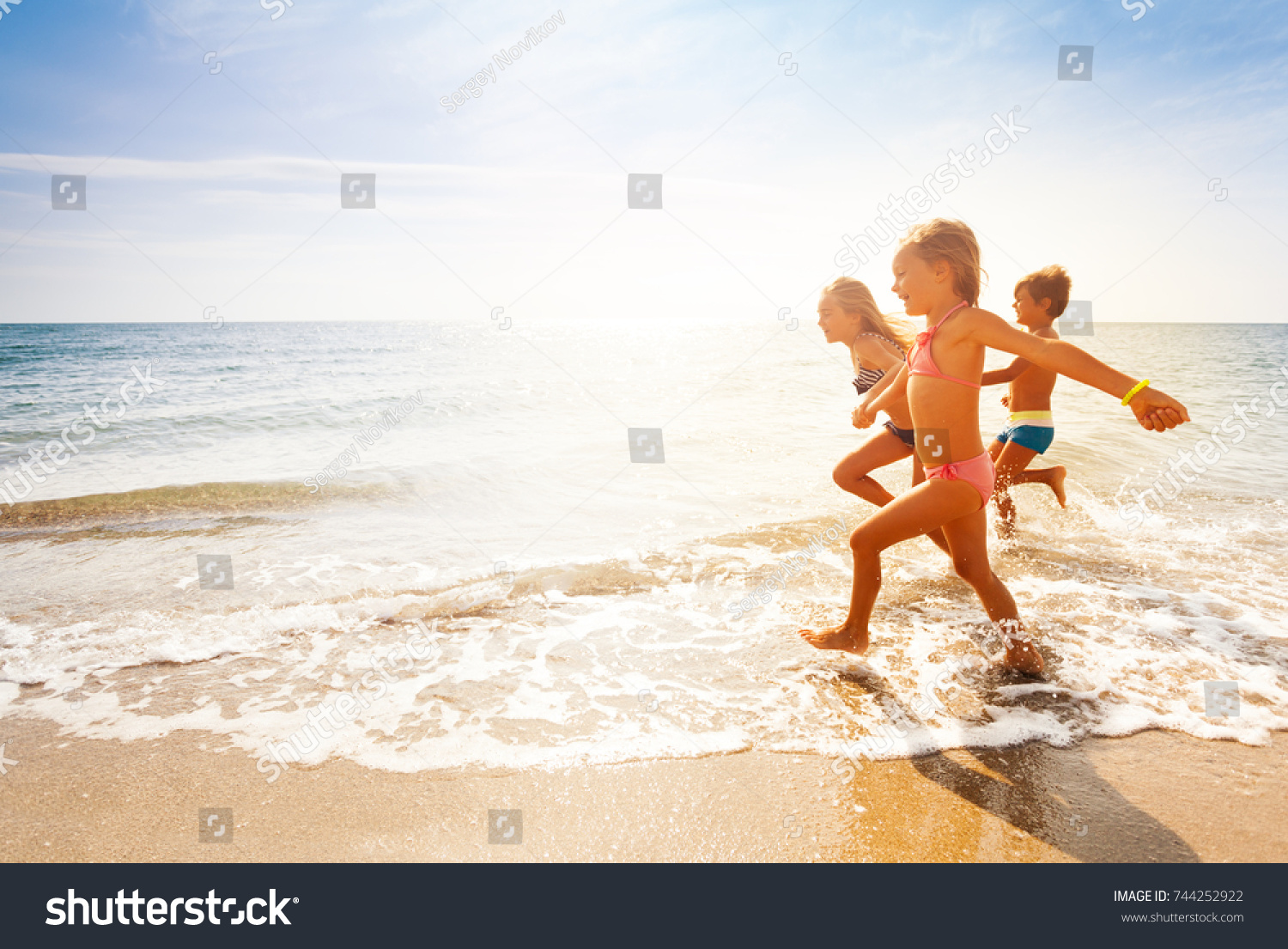 Cute kids having fun on sandy beach in summer #744252922