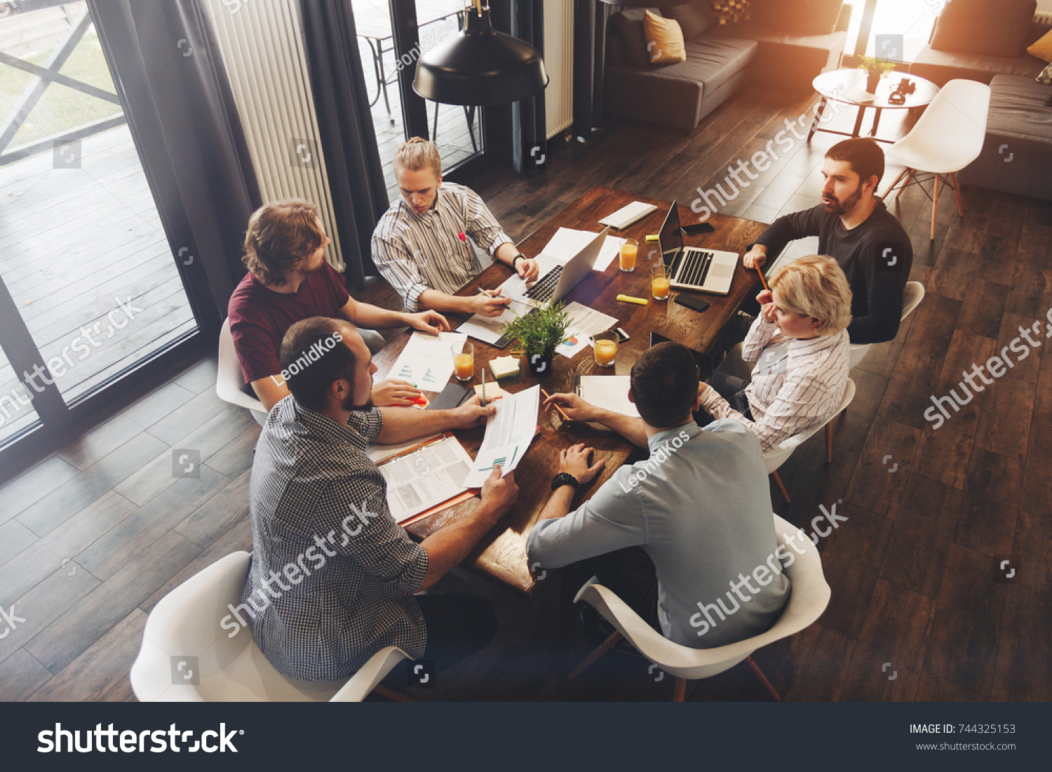 Teamwork on new business project in loft space. Group coworkers making great business decisions. Creative managers discussion work concept modern office #744325153