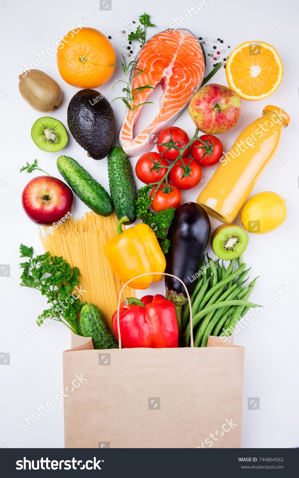 Healthy food background. Healthy food in full paper bag of different products fish, vegetables and fruits on white background. Top view #744864562