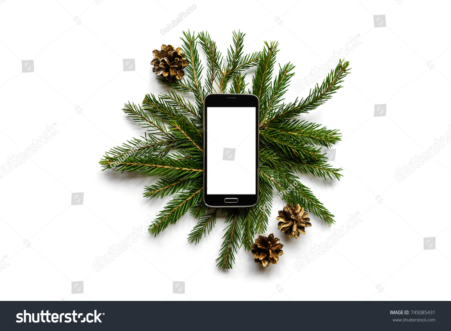 Christmas flatlay of fir branches and pine cones and smartphone with blank screen copy space for text, top view #745085431