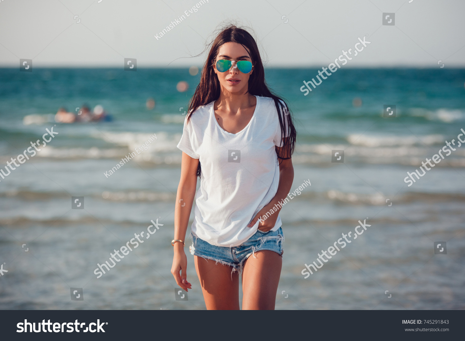 Girl in a white t-shirt on the background of the ocean. Mock-up. #745291843