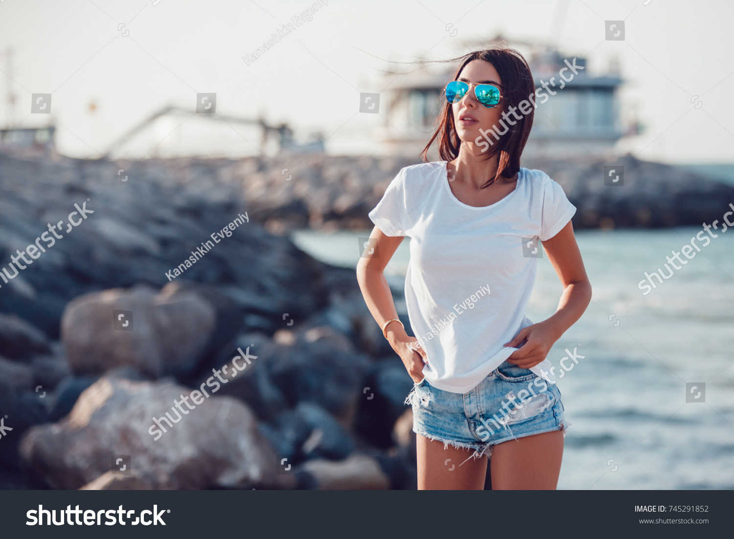 Girl in a white t-shirt on the background of the ocean. Mock-up. #745291852