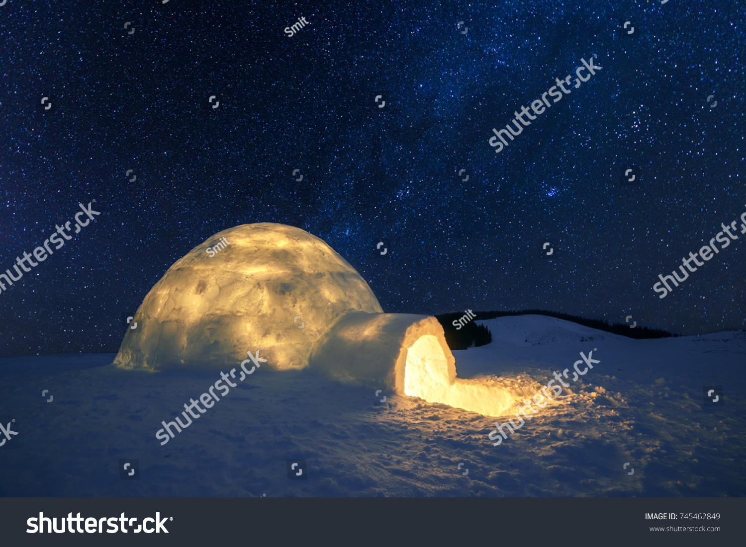 Fantastic winter landscape glowing by star light. Wintry scene with snowy igloo and milky way in night sky. Carpathian mountains. Santa house from snow,  ideal New Year and Christmas background  #745462849
