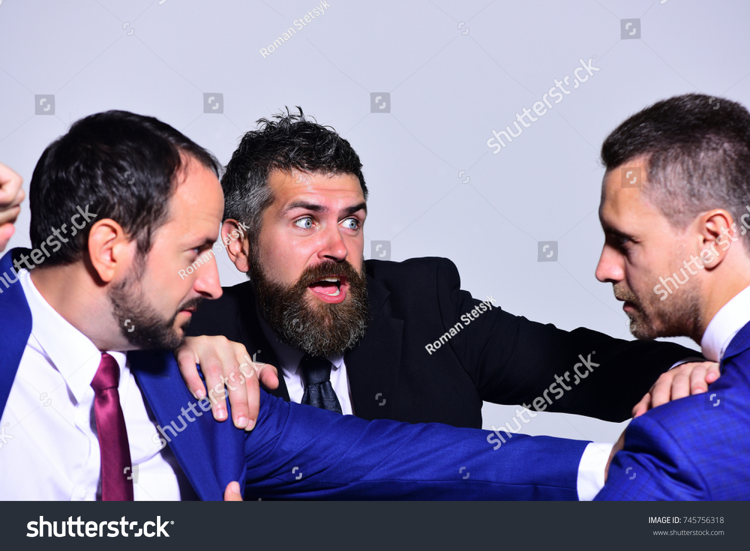 Businessmen with strict and scared faces in formal wear on grey background. Coworkers decide upon best working position. Business conflict and argument concept. Leaders fight for business leadership #745756318