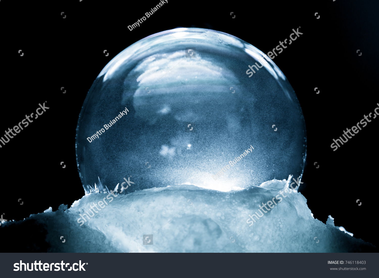 Frozen snow globe christmas magic ball with flying snowflakes. Winter Background. Christmas and New Year Holidays precious backdrop. Ice patterns frosted on ball of soap against dark black abstract #746118403
