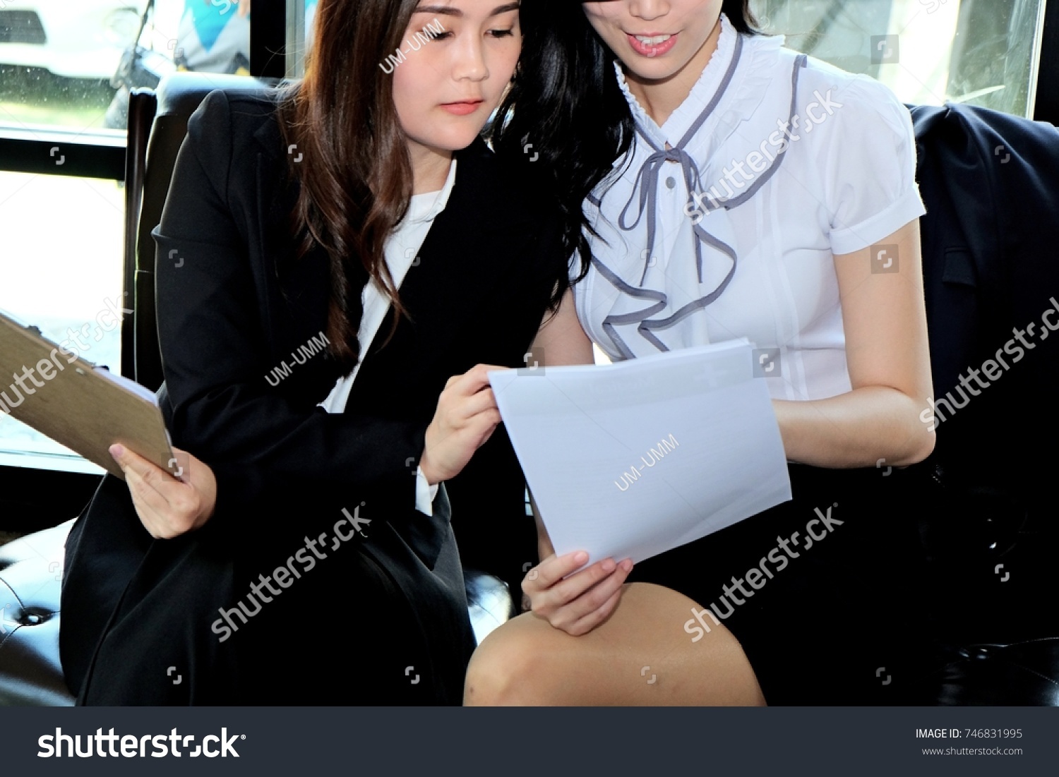 Two businesswoman working together about documents, partner discuss plan or idea and opinion meeting, Asian bussiness are discussing their working on a wood table beside window at coffee shop  #746831995