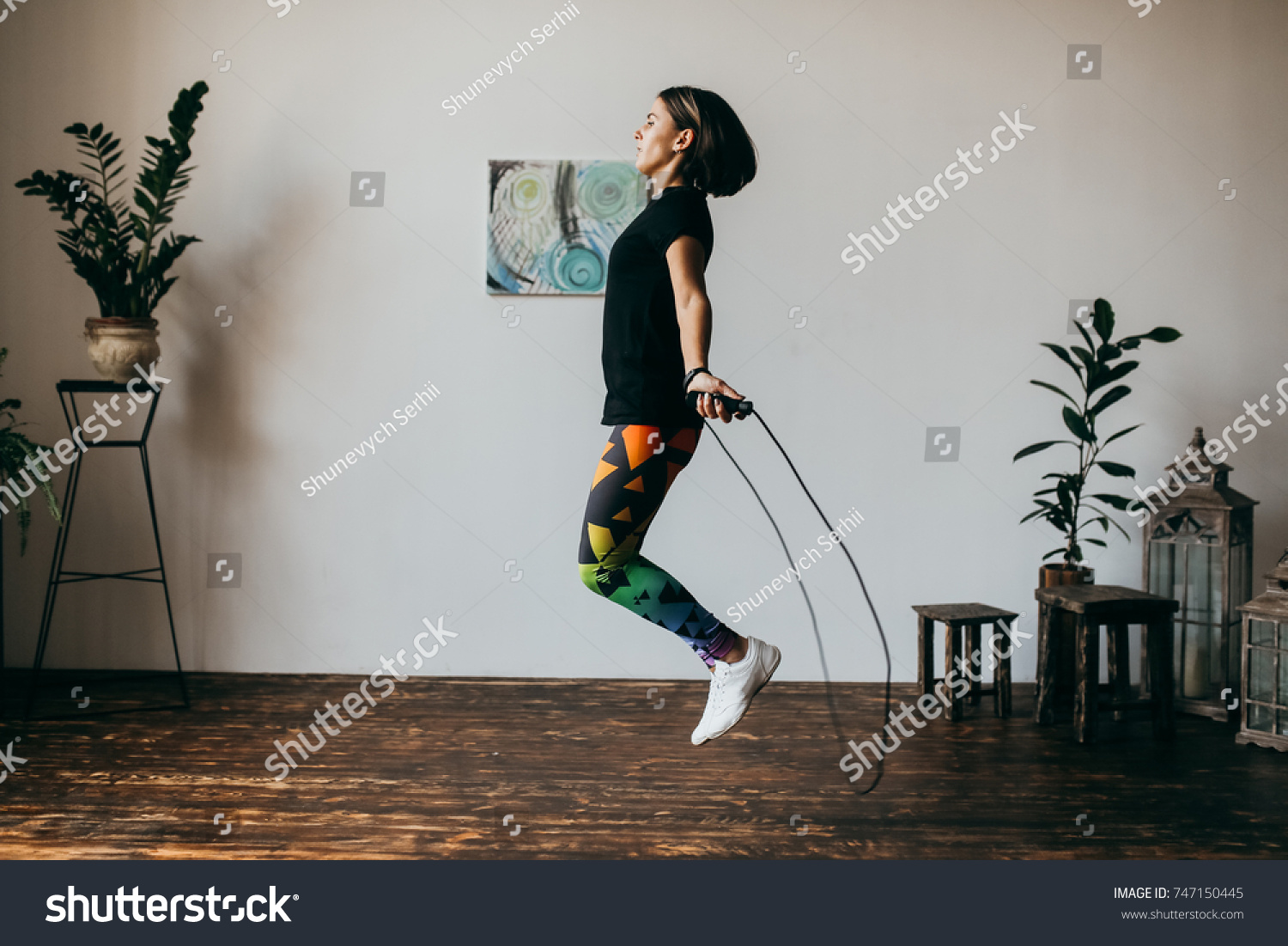 Young fitness woman jumping rope at home #747150445
