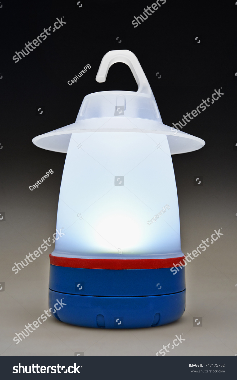 Modern plastic camping light on table illuminated and isolated #747175762