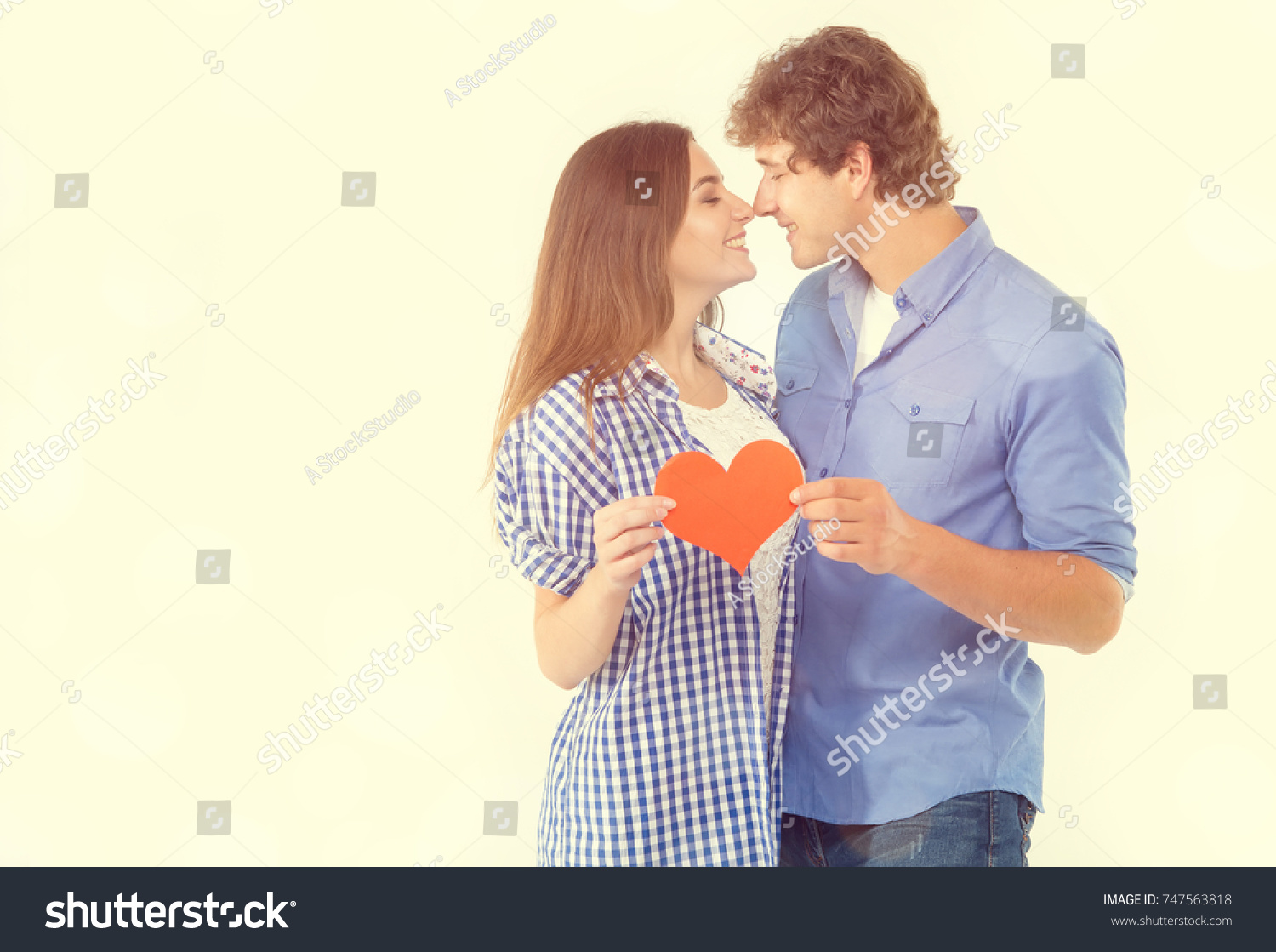 Happy loving couple. Enamored couple of young people. Man and woman holding in their hands red hearts. Symbol of love. Valentine's Day. #747563818