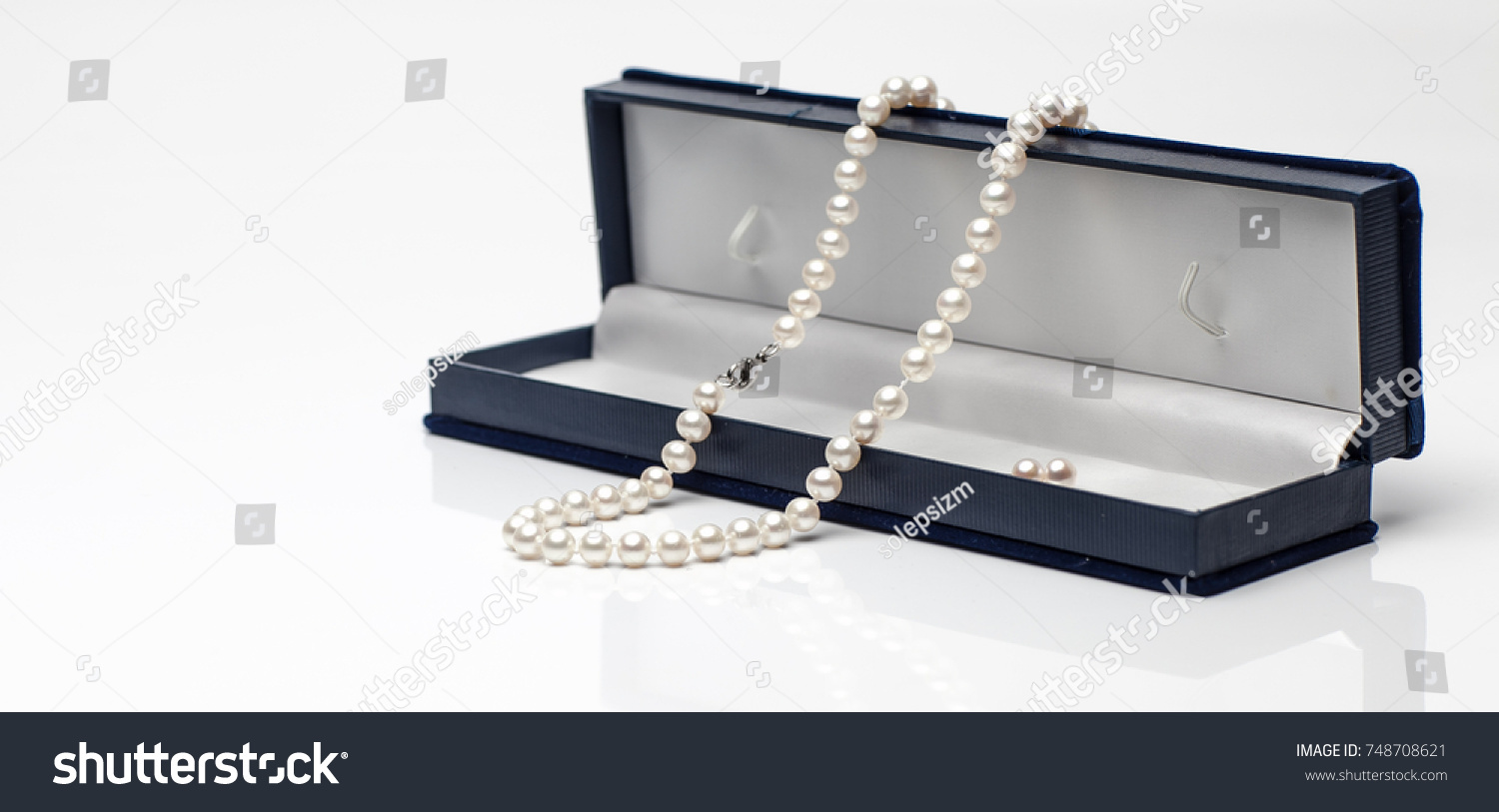 White pearl necklace in a black velvet box on isolated white background. #748708621