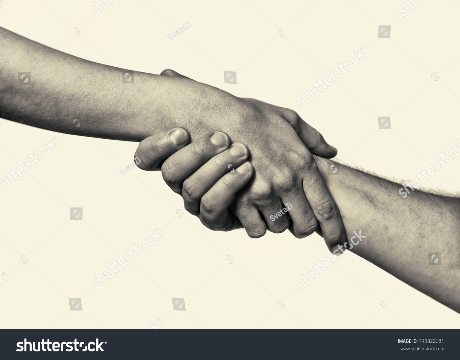 Concept of salvation. Black and white image of the hands of two people at the time of rescue (help). #748822681