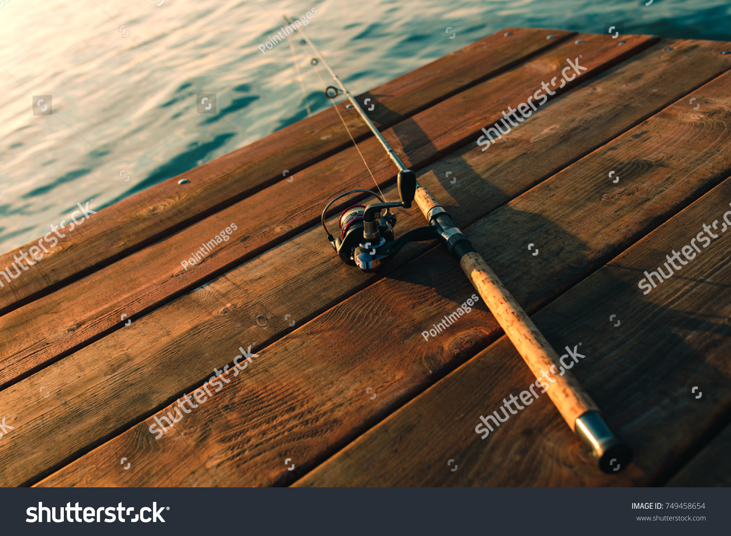 Fishing rod on a wooden dock. #749458654