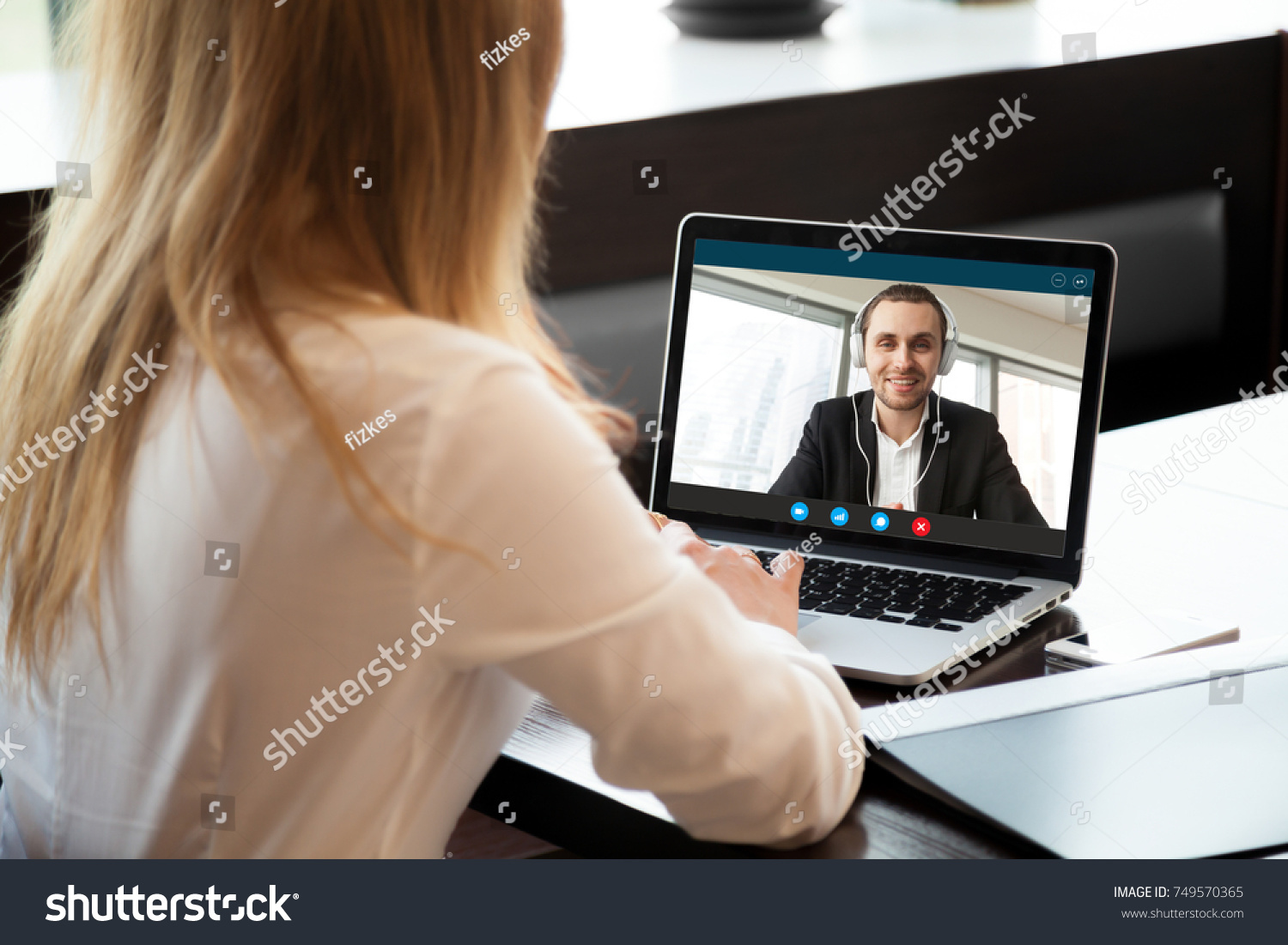 Businesswoman making video call to business partner using laptop. Close-up rear view of young woman having discussion with corporate client. Remote job interview, consultation, human resources concept #749570365
