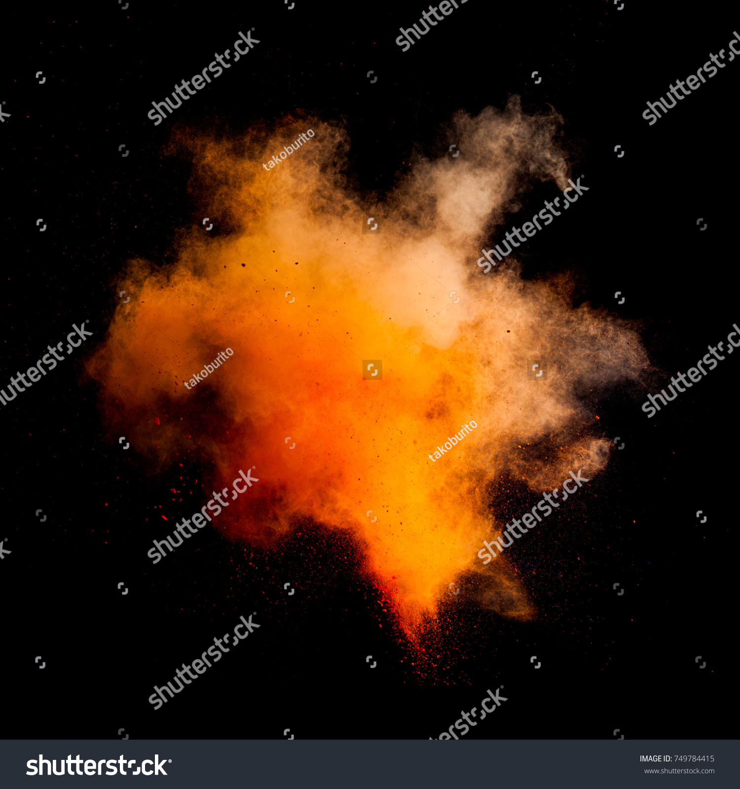 Freeze motion of orange dust explosion isolated on black background #749784415