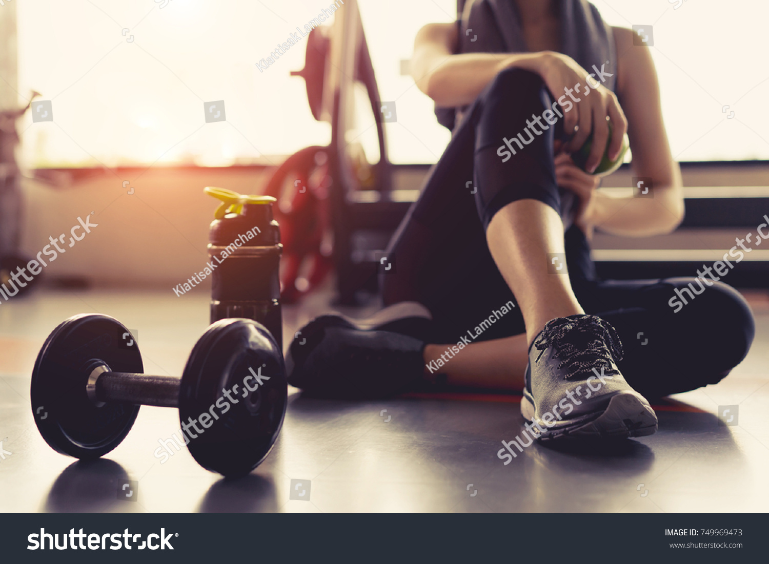 Woman exercise workout in gym fitness breaking relax holding apple fruit after training sport with dumbbell and protein shake bottle healthy lifestyle bodybuilding, Athlete builder muscles lifestyle. #749969473