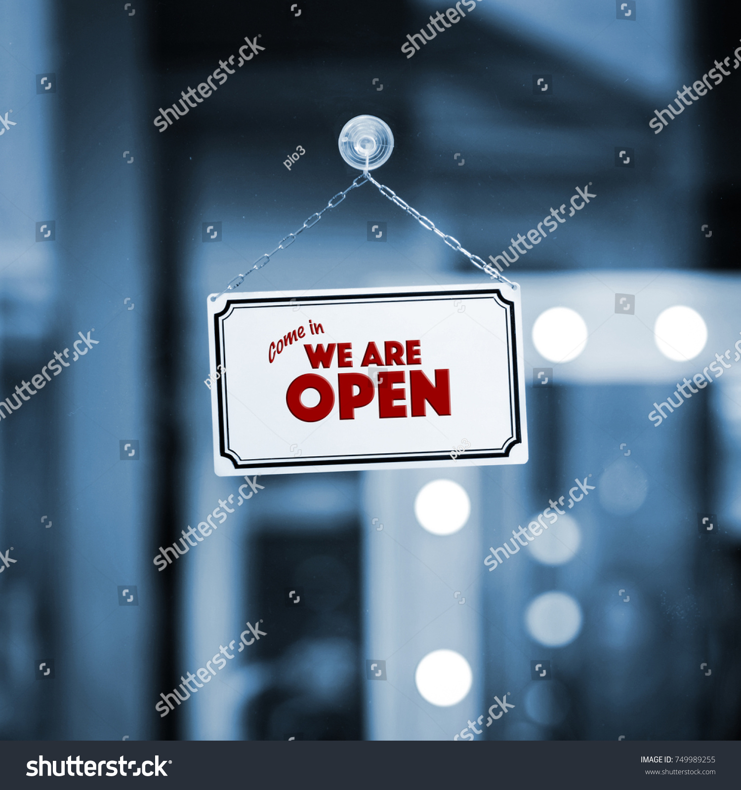 WE ARE OPEN sign board through the glass of store window. Filtered image. #749989255